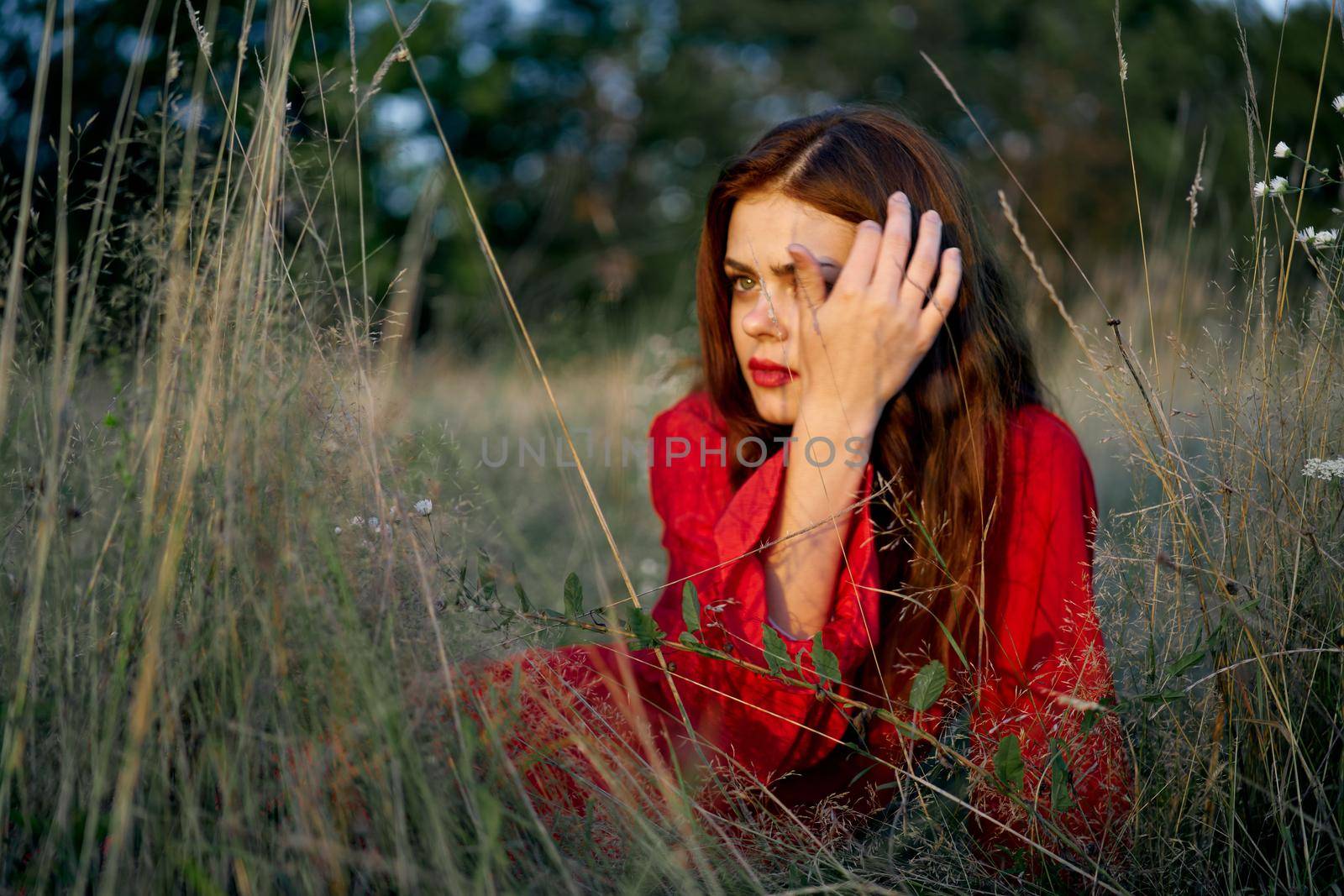 woman in a red dress lies on the grass in the field nature fashion by Vichizh