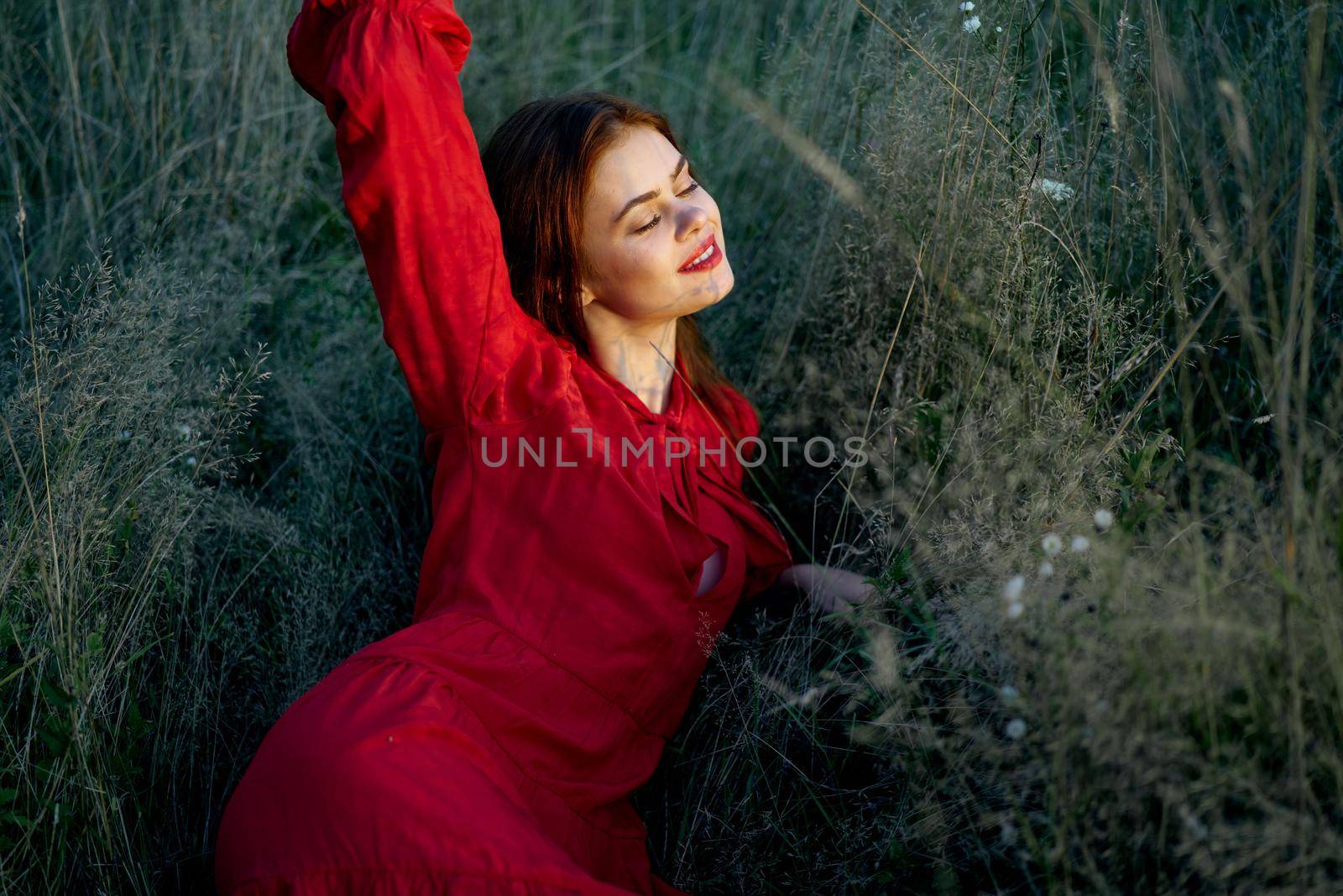 pretty woman in red dress lies on the grass nature sun by Vichizh