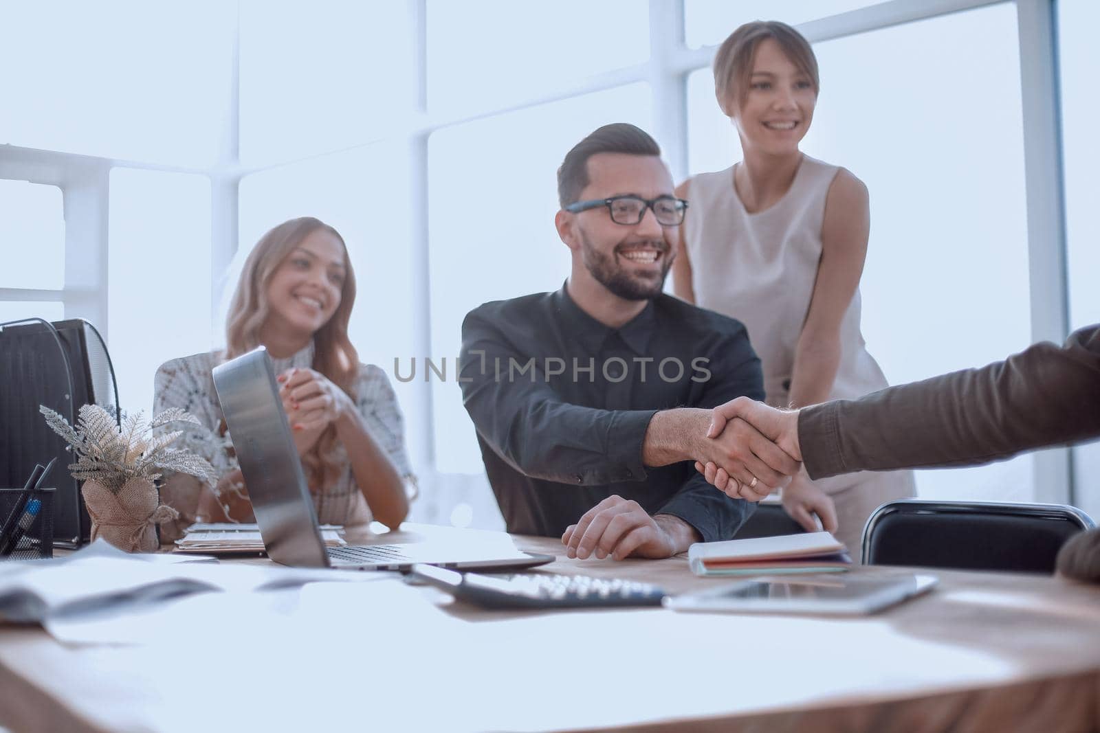 background image of the handshake of business partners in the office. business concept