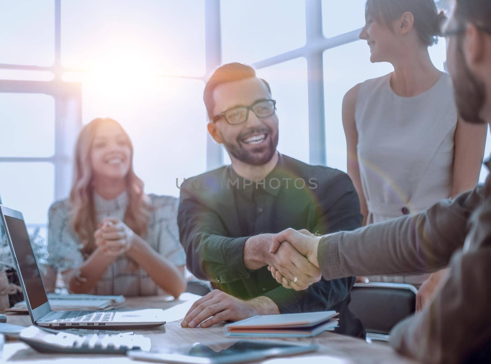 background image of the handshake of business partners in the office. business concept