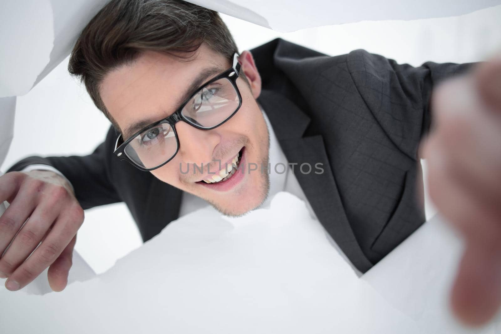 happy businessman with glasses looking through a hole in the paper by asdf