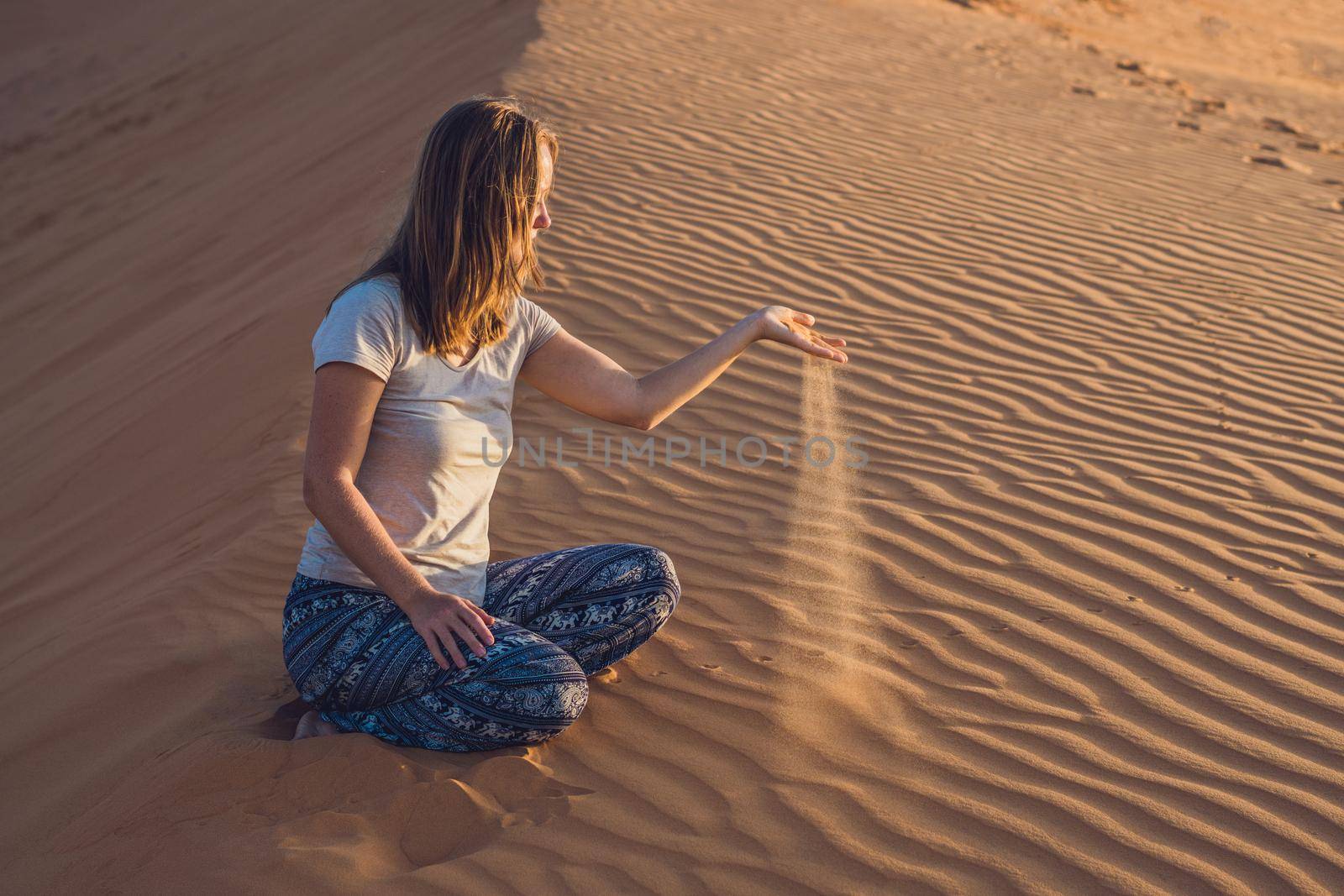 young woman in rad sandy desert at sunset by galitskaya