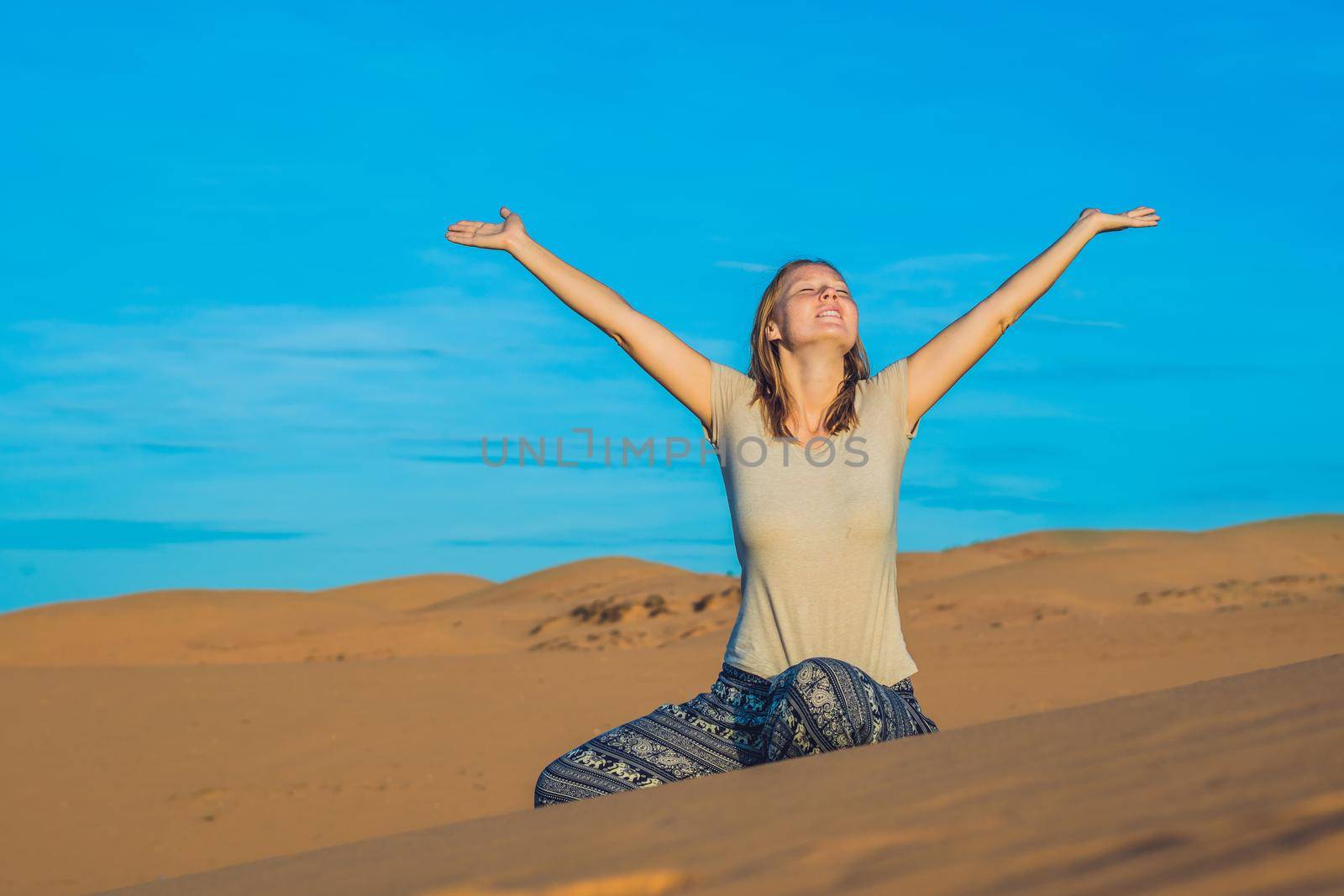 young woman in rad sandy desert at sunset or dawn