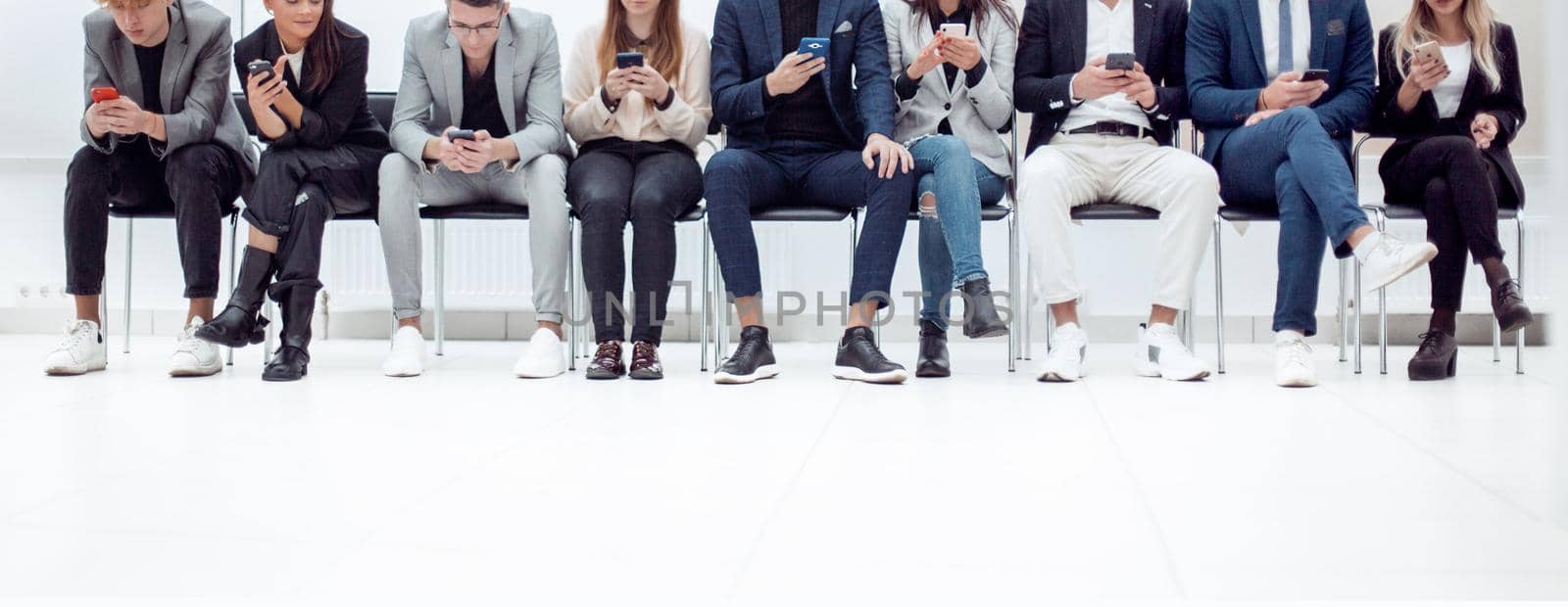 group of diverse young business people looking at their smartphone screens. photo with copy space