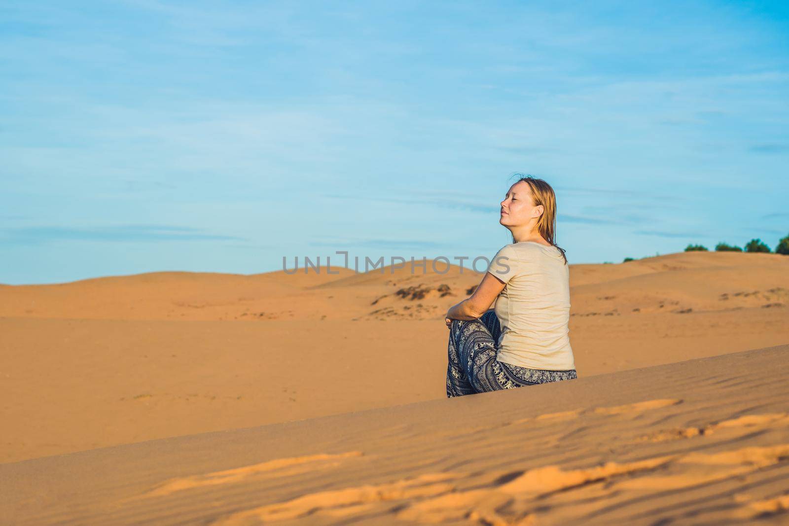 young woman in rad sandy desert at sunset by galitskaya