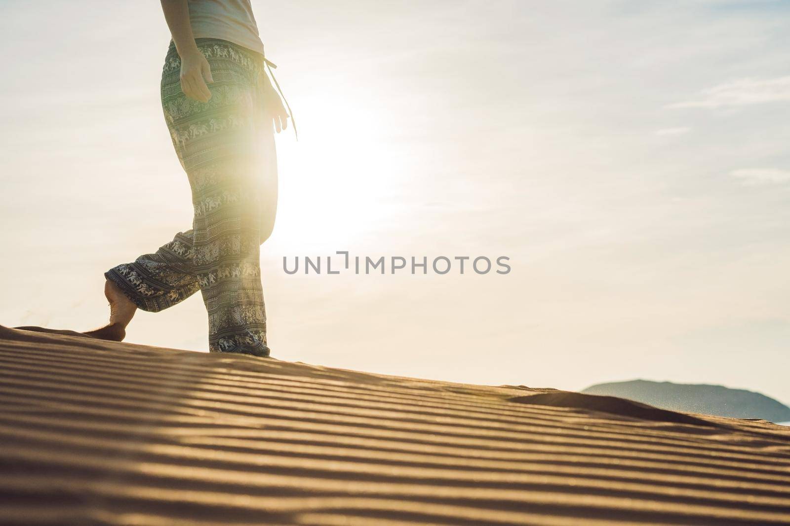 young woman in rad sandy desert at sunset by galitskaya