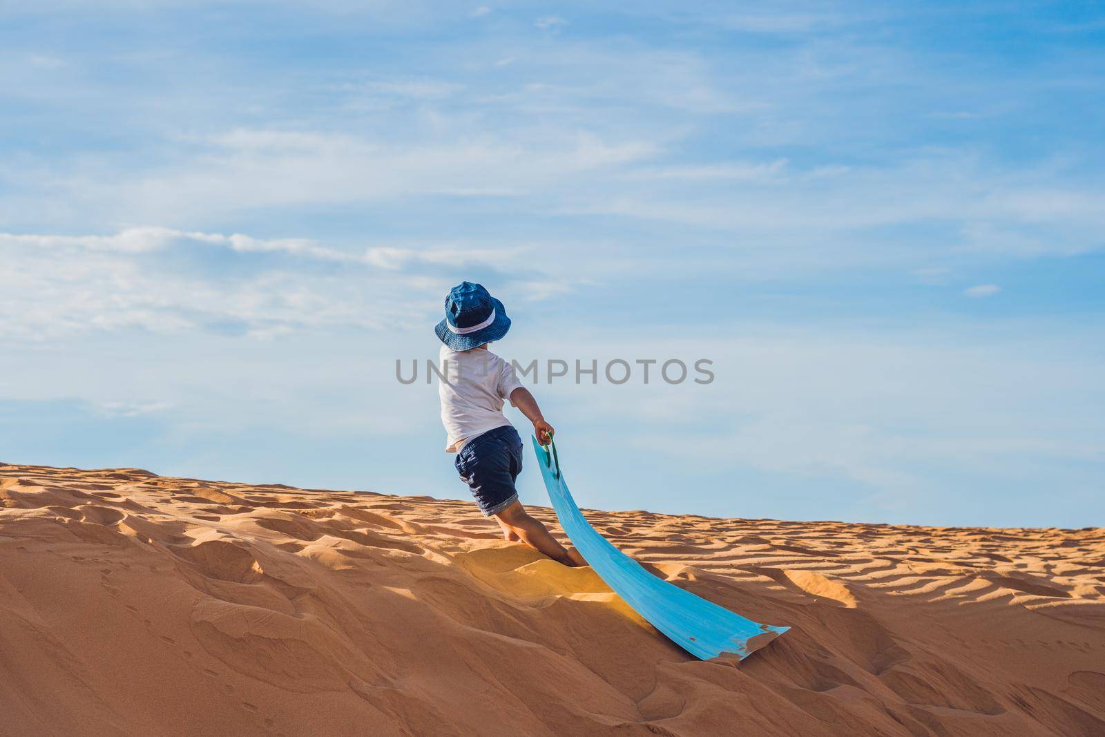 The boy in the red desert at dawn. Traveling with children concept.