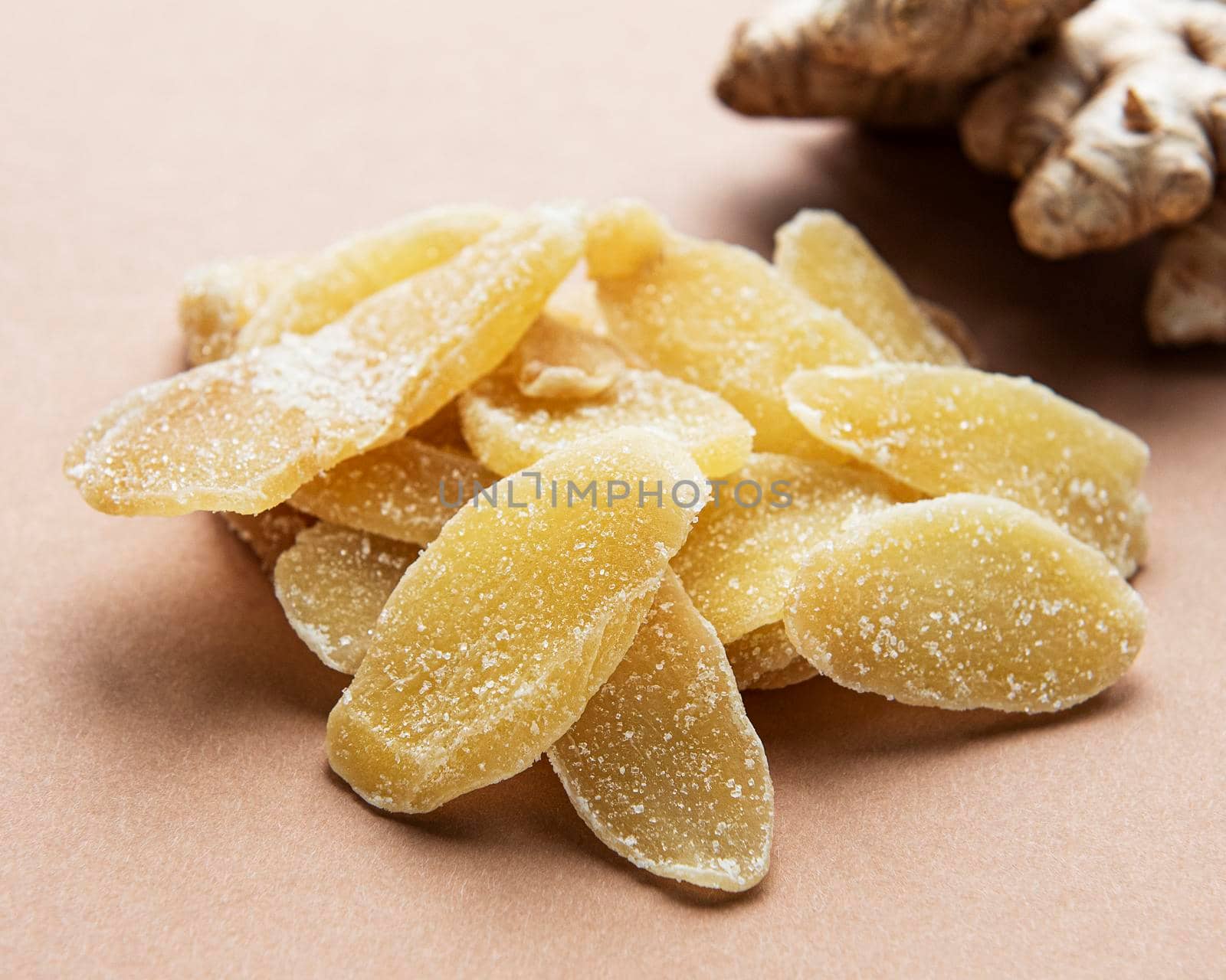 Sweet and spicy candied ginger on a brown background