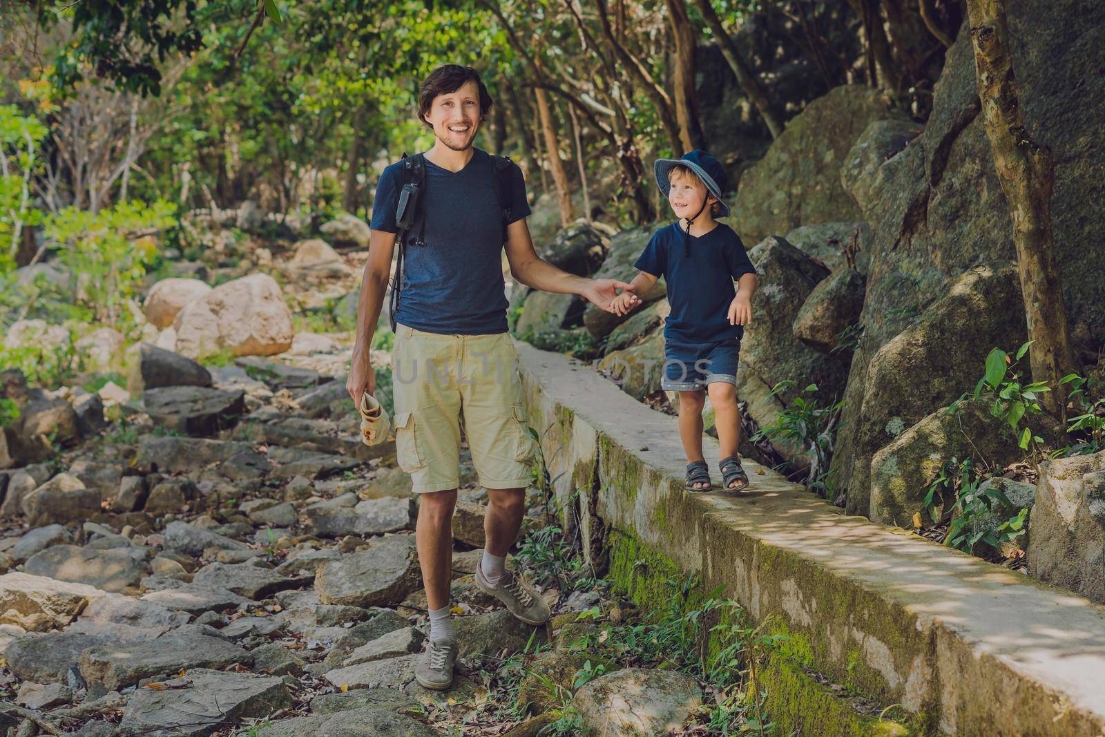 Father and son are walking along the forest road.