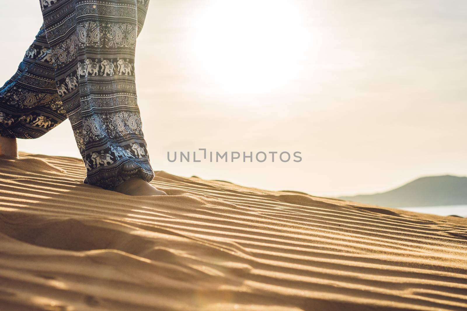 young woman in rad sandy desert at sunset or dawn