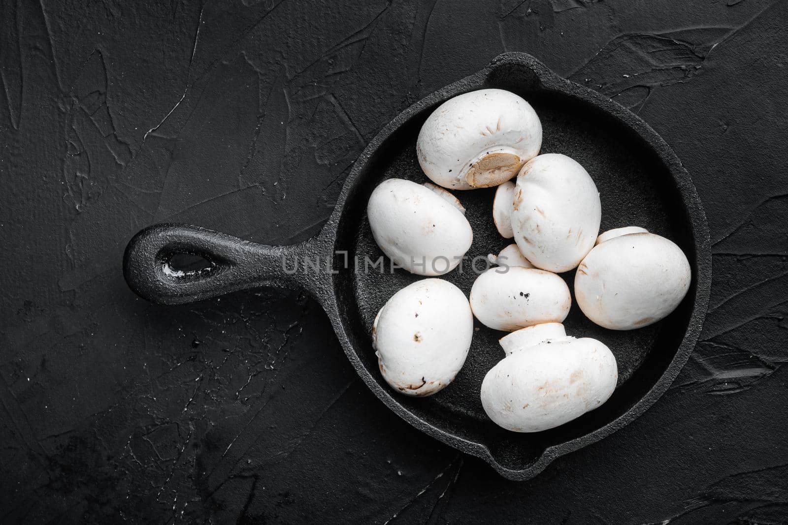 Mushroom champignon set, on black stone background, top view flat lay