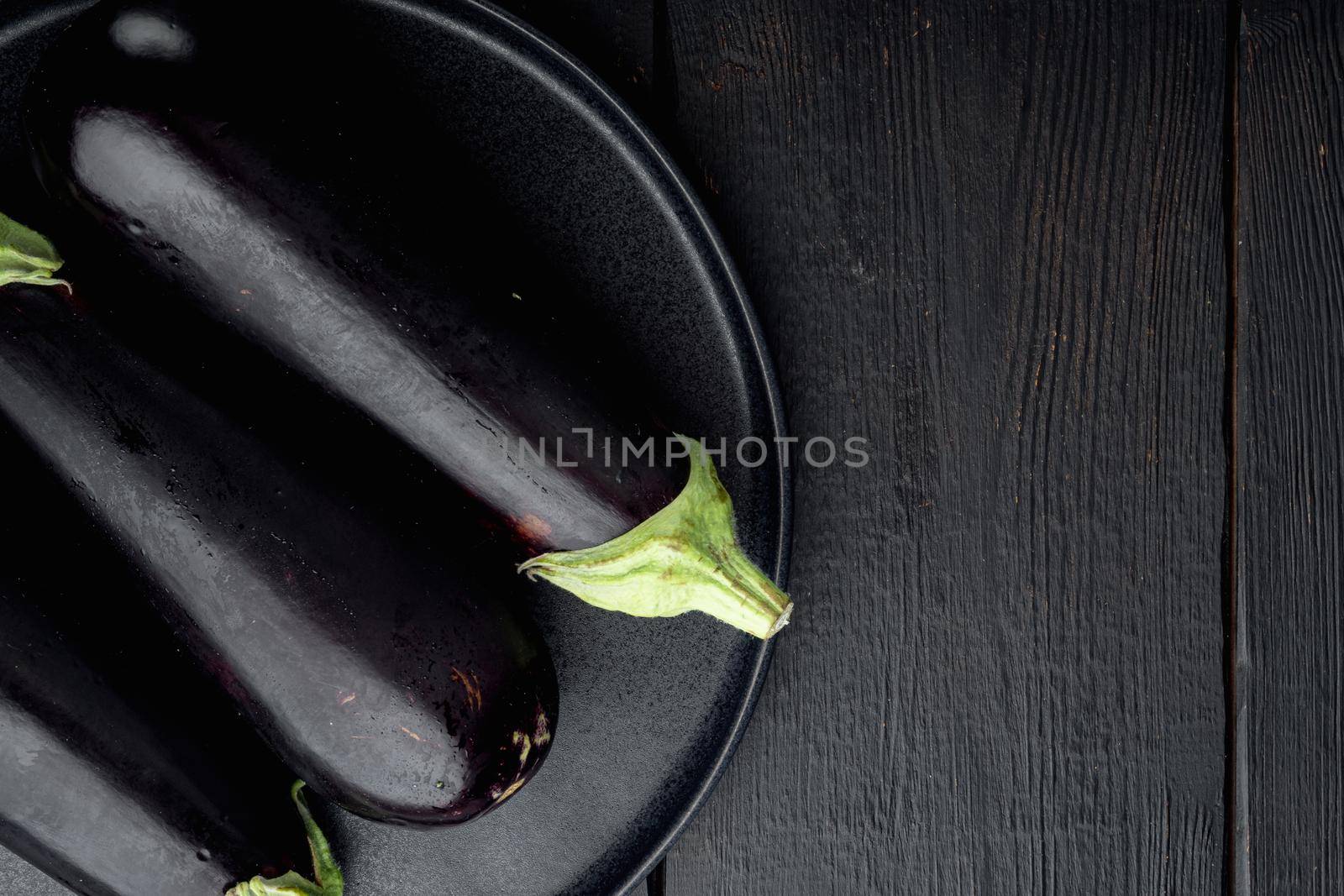 Fresh raw Purple Eggplant set, on black wooden table background, top view flat lay, with copy space for text
