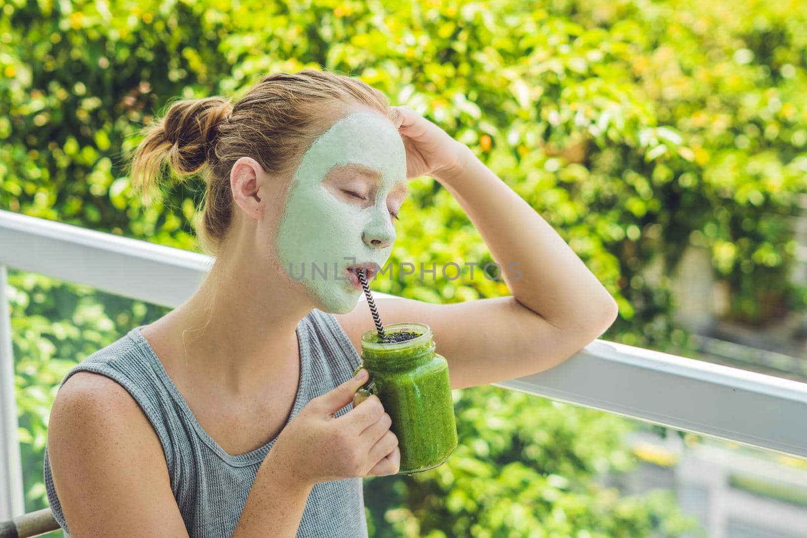 Spa Woman applying Facial green clay Mask. Beauty Treatments. Fresh green smoothie with banana and spinach with heart of sesame seeds. Love for a healthy raw food concept. Detox Concept by galitskaya