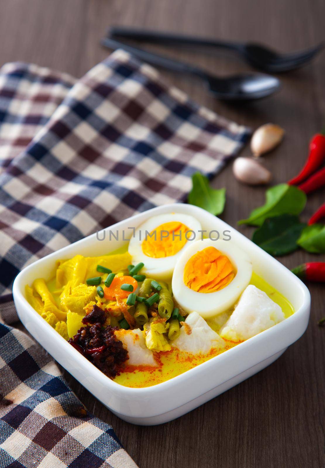 “ Lontong Ketupat / Lontong Kupat ” or Rice Cake and coconut gravy with tumeric, chilli, and vegetables. A famous Malaysian and Indonesia food.