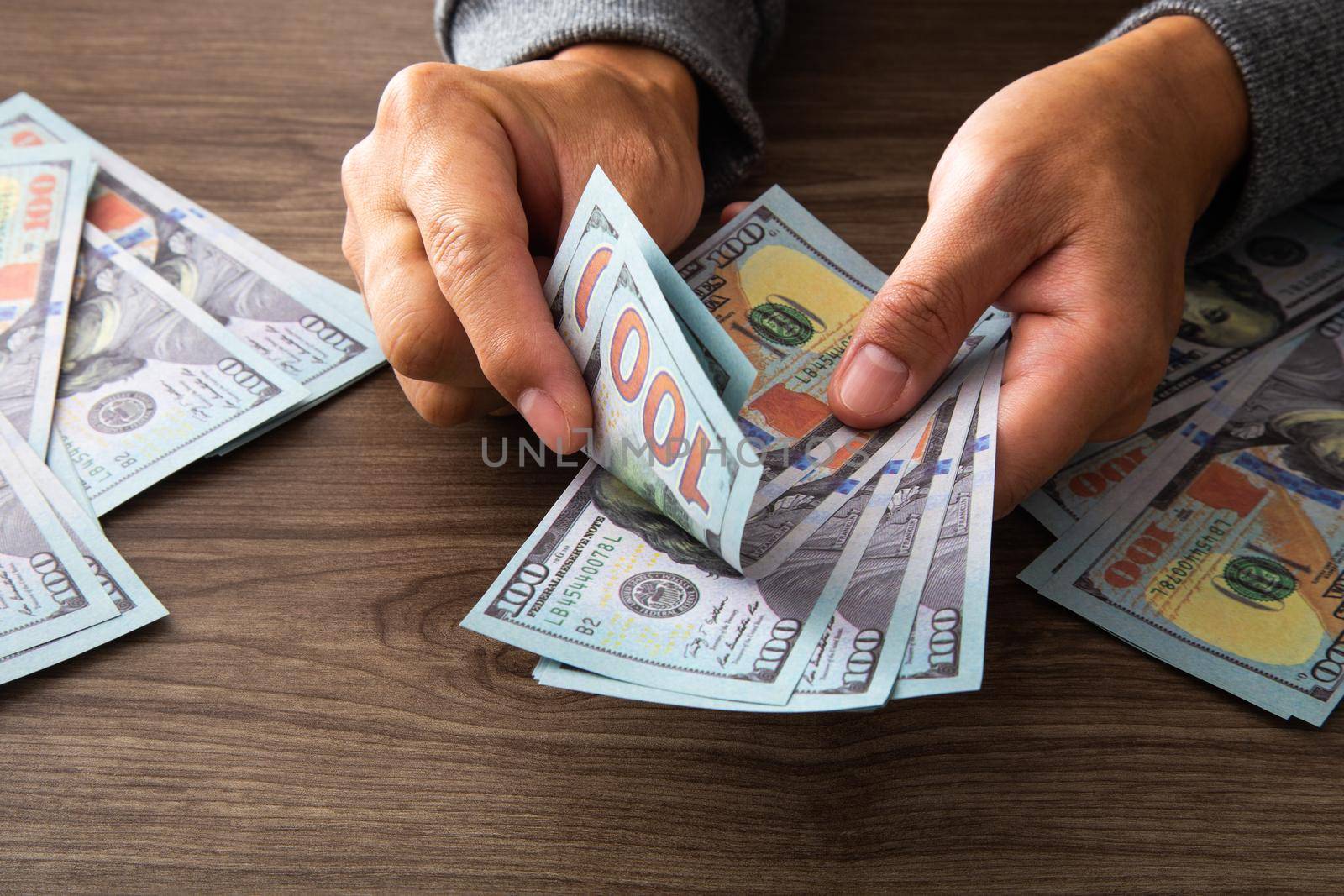 Man counting paper dollar banknotes. 100 usd dollar bills in hands close up. Success and wealth business concept.