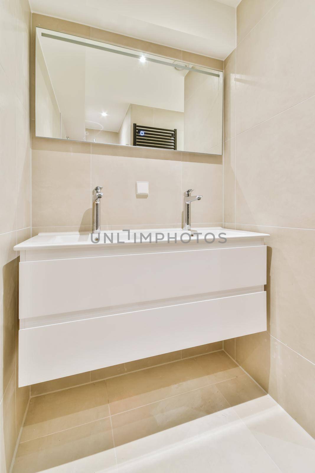 Expensive vessel sink made of natural stone with white faucet under mirror in bathroom