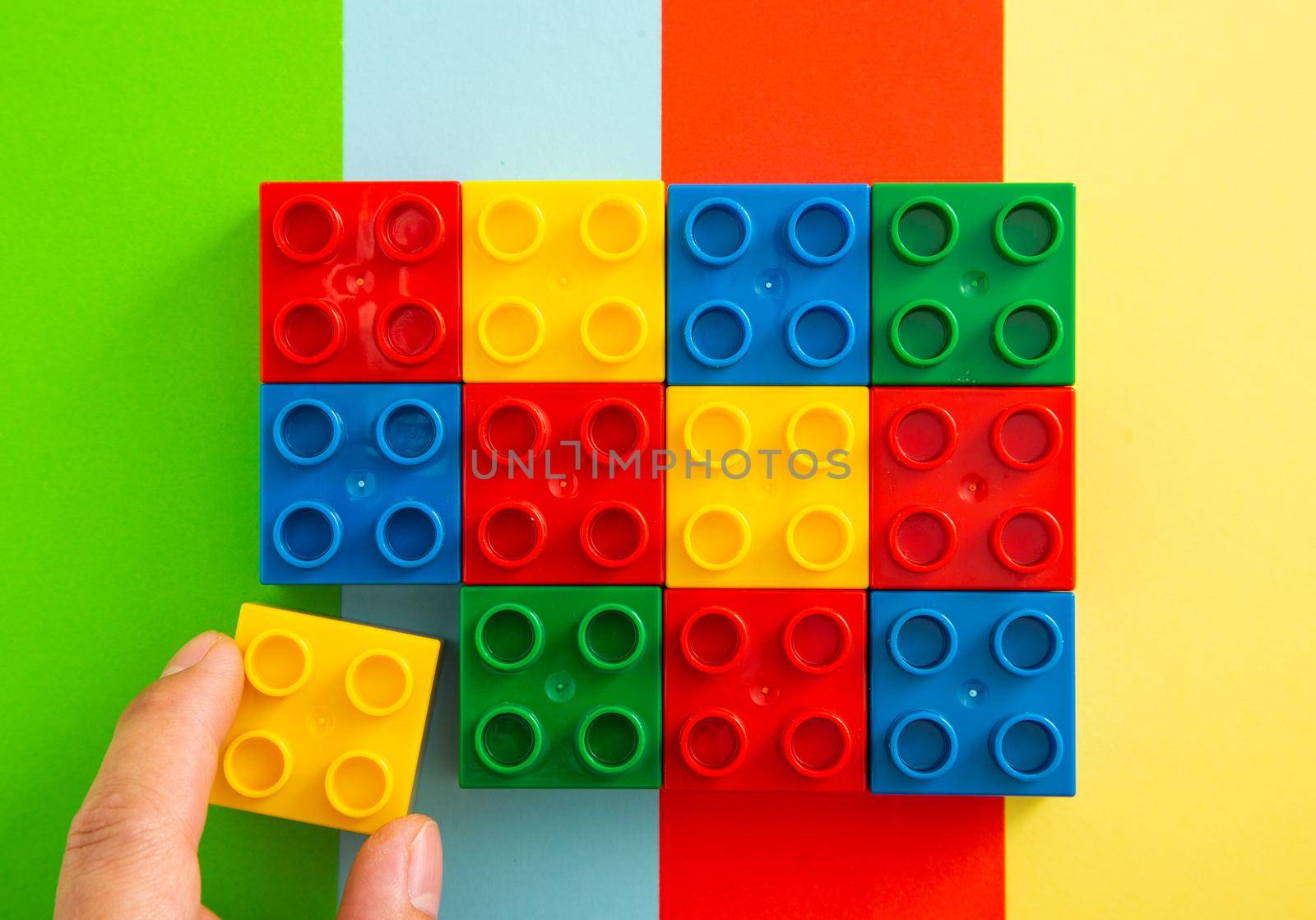 Colorful plastic block on colorful background. (Flat Lay)