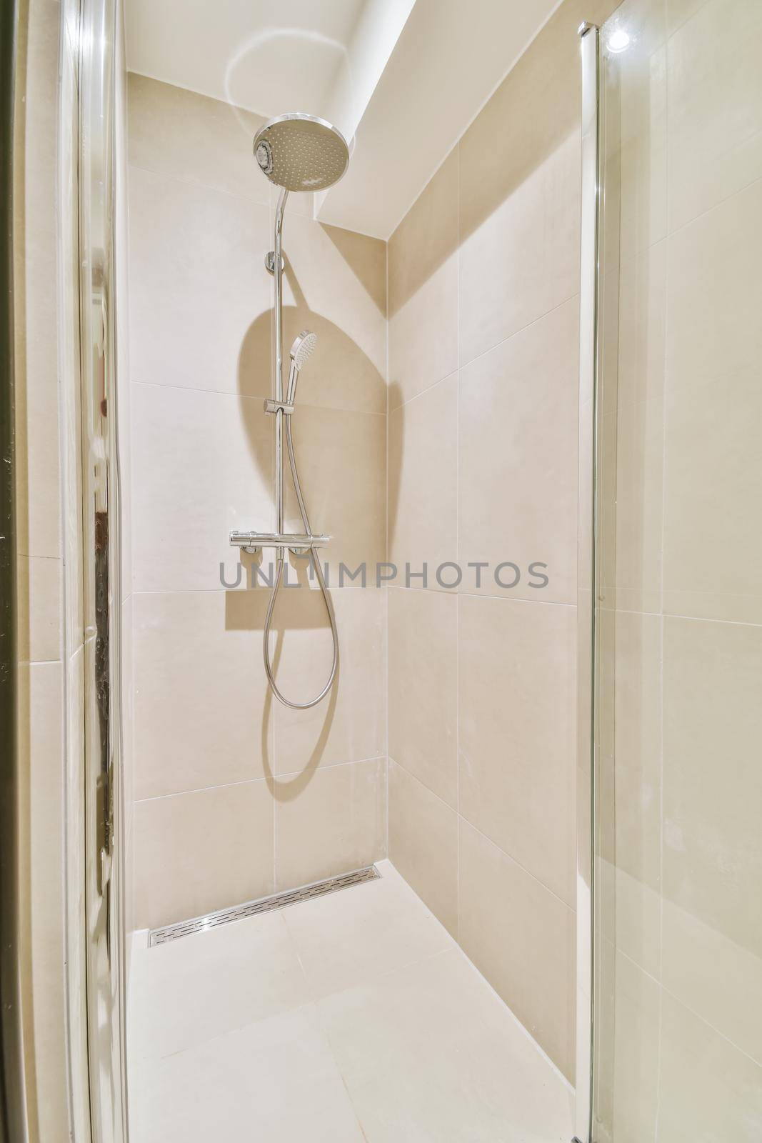 Shower tap in tiled bathroom by casamedia