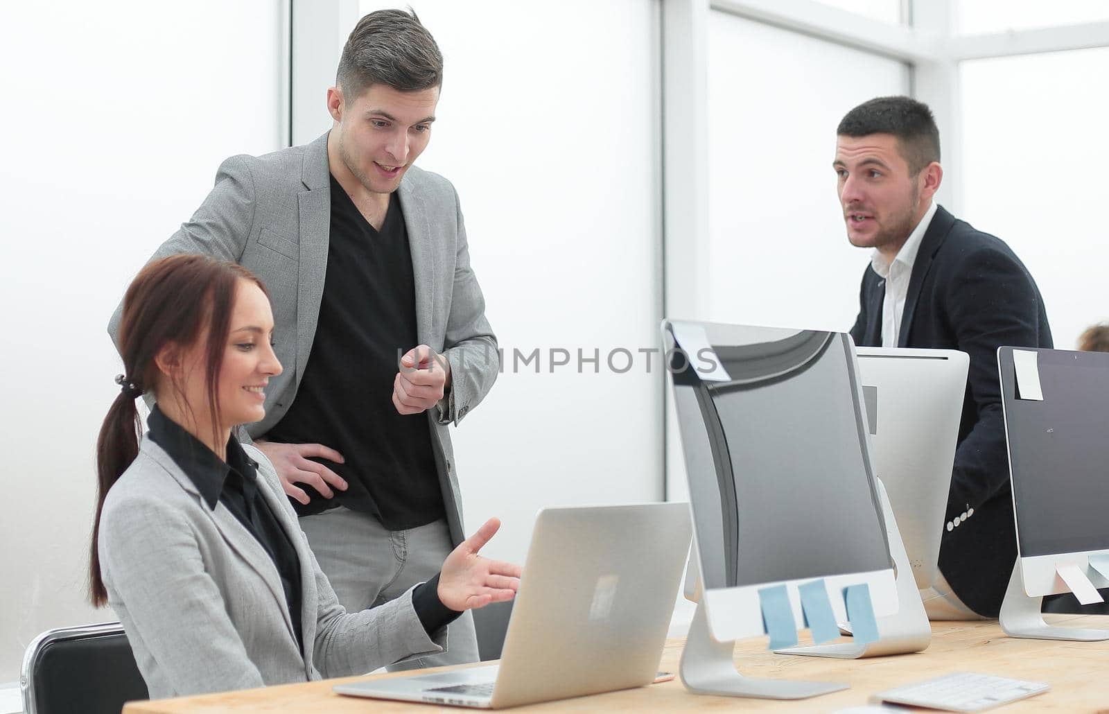 business team discussing work issues standing in the office . photo with a copy-space