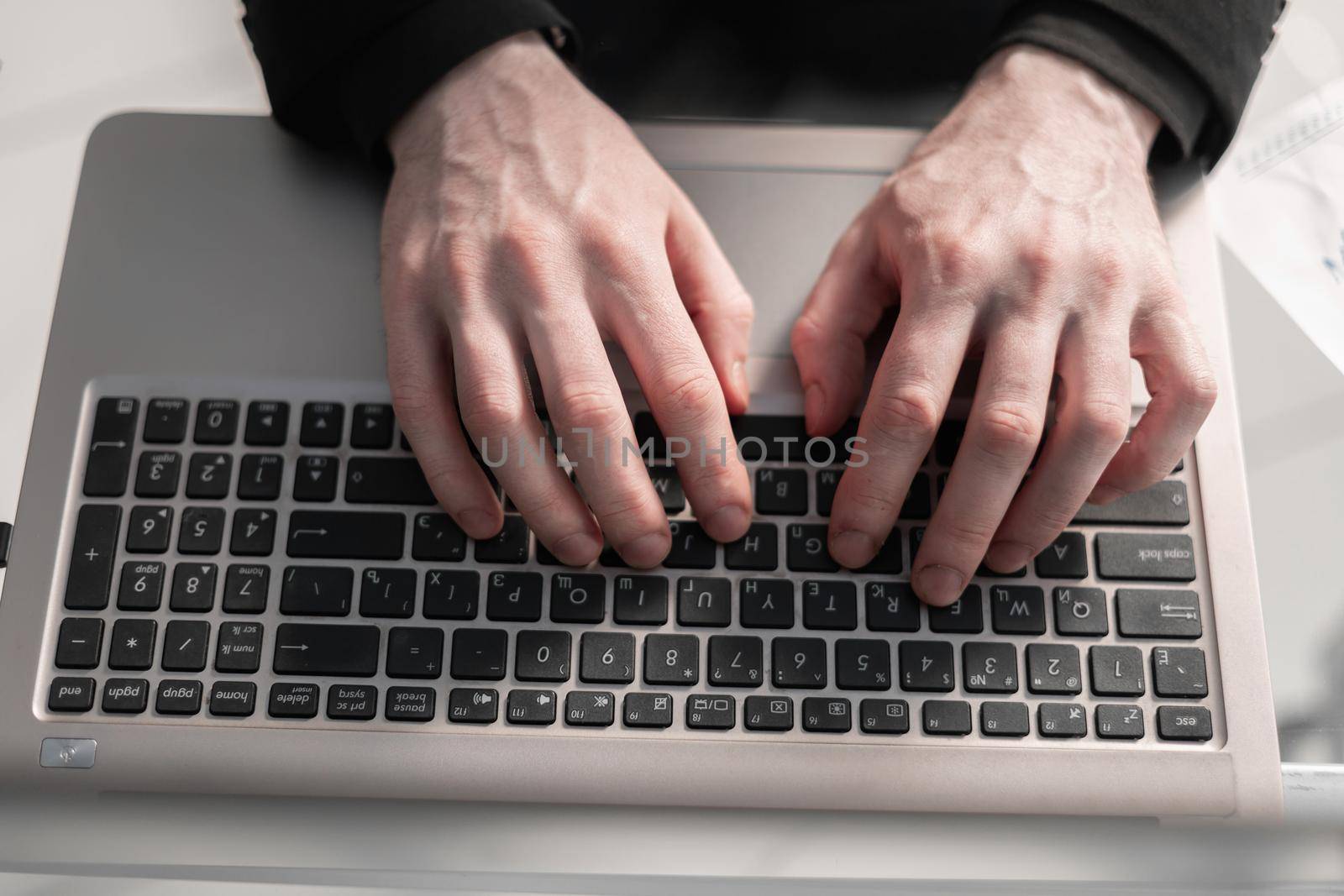 Man's hands typing on laptop keyboard by asdf
