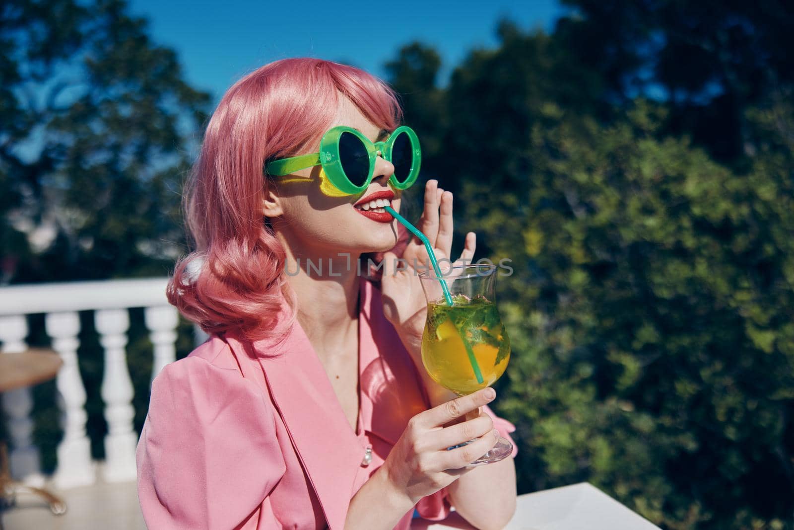 portrait of beautiful woman in green sunglasses with cocktail in summer outdoors Summer day. High quality photo