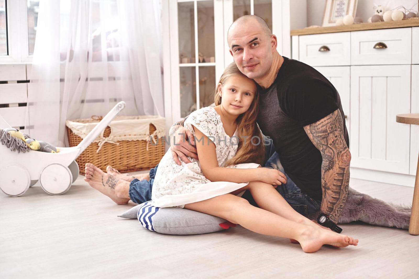 Adorable daughter wearing a white dress whith her loving father in a modern kid's room whith a wooden furniture. Happy family. by nazarovsergey