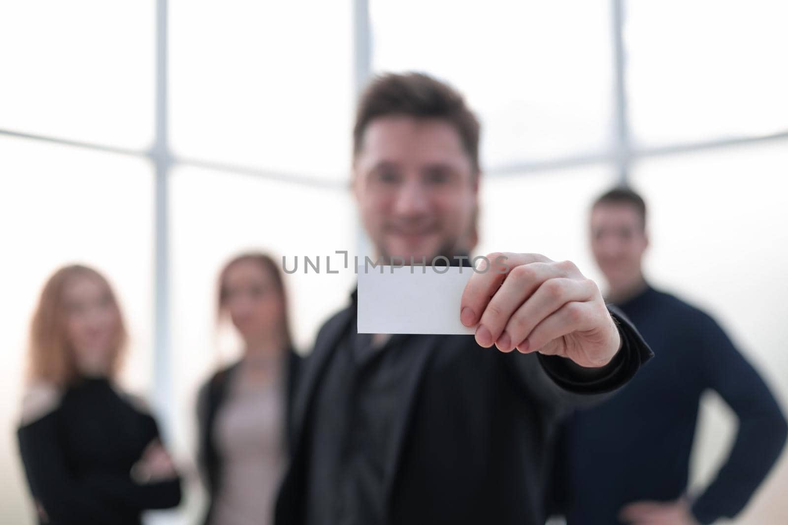 A handsome businessman showing a blank piece of paper. Close-up by asdf