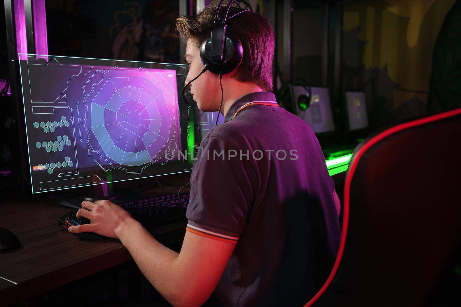 Professional photo of young male caucasian cyber sportsman in gaming club training for important match. Back view. laser screen, projector, augmented reality, AR, VR