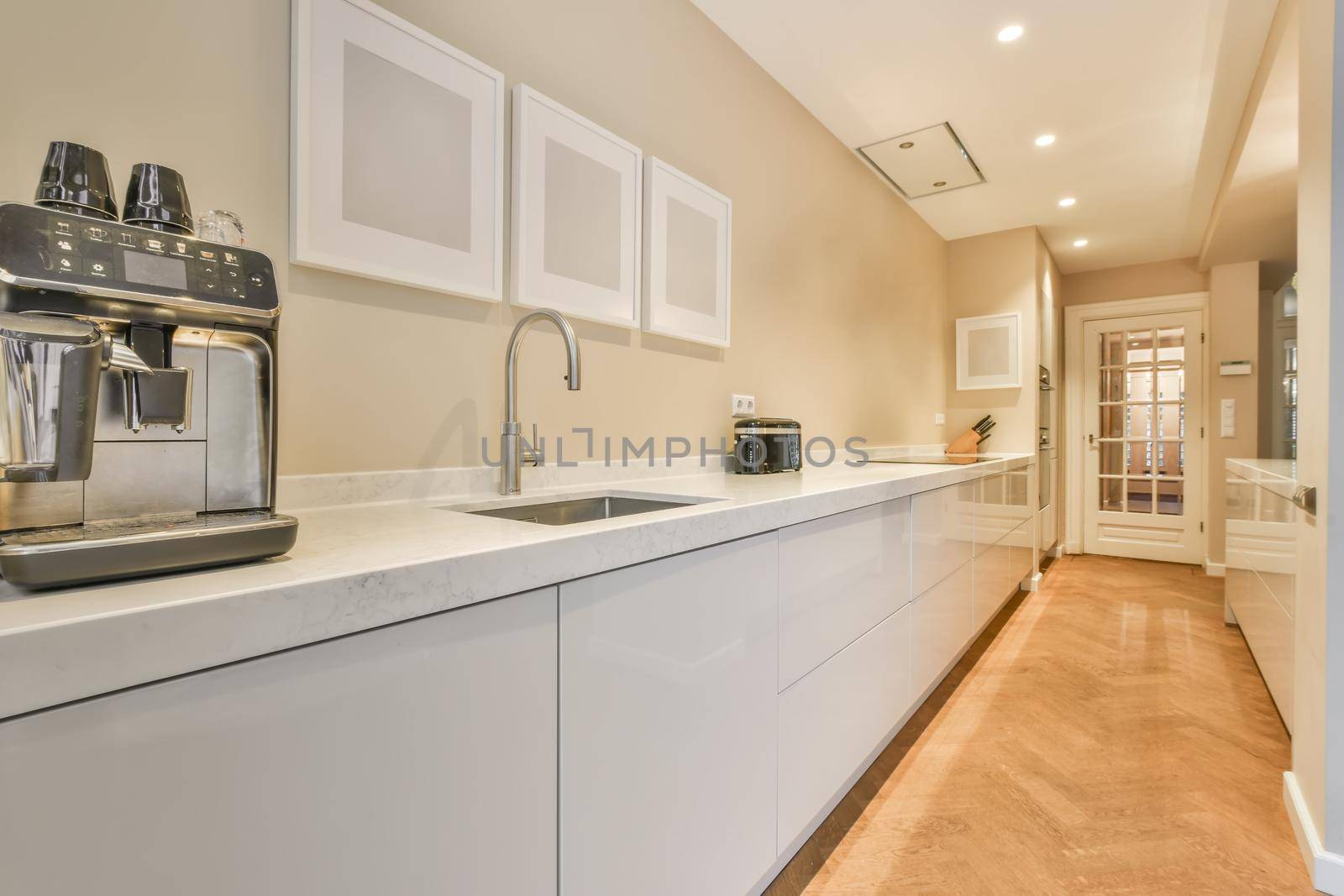 Interior of the light kitchen with modern appliances in a modern flat at daytime