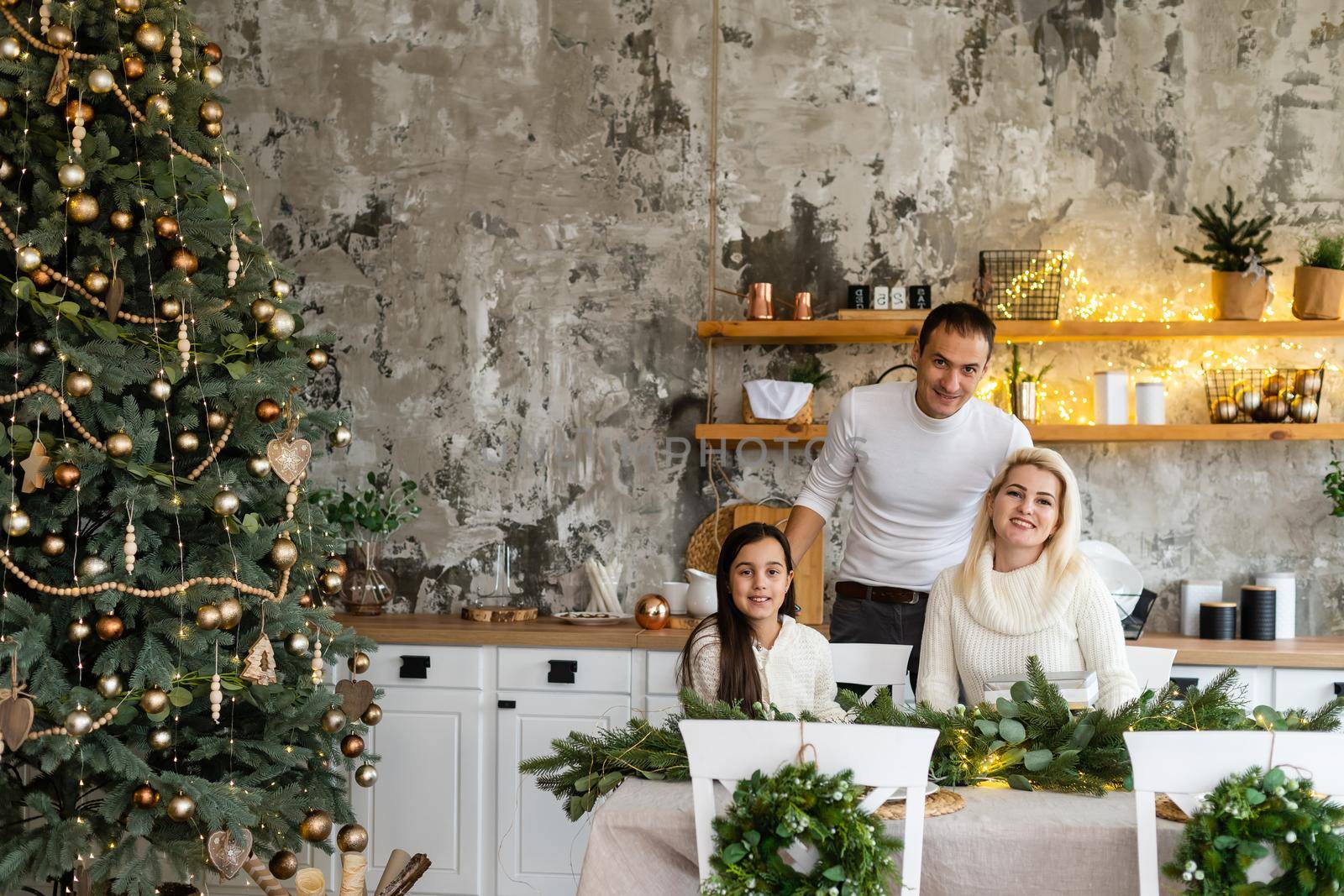 Young family celebrating Christmas at home. Happy young family enjoying their holiday time together.