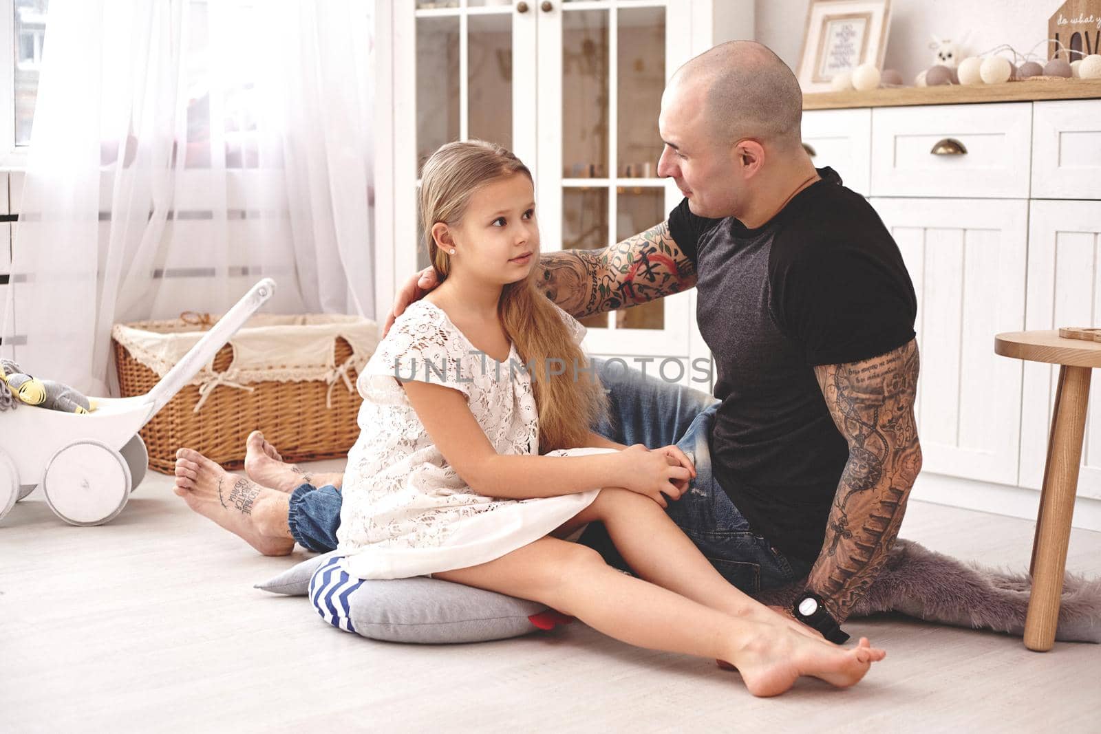 Adorable daughter wearing a white dress whith her loving father in a modern kid's room whith a wooden furniture. Happy family. by nazarovsergey