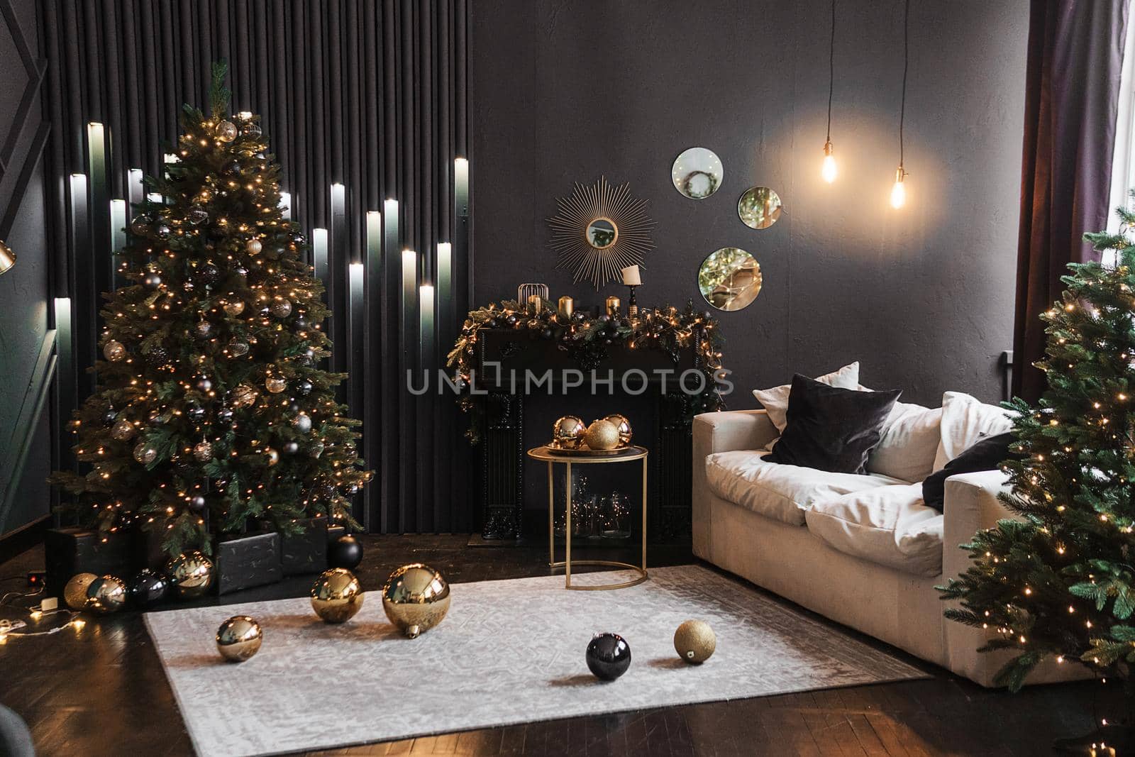 Christmas interior with a beautiful Christmas tree, sofa, light bulbs and dark background. Home New Year's interior.