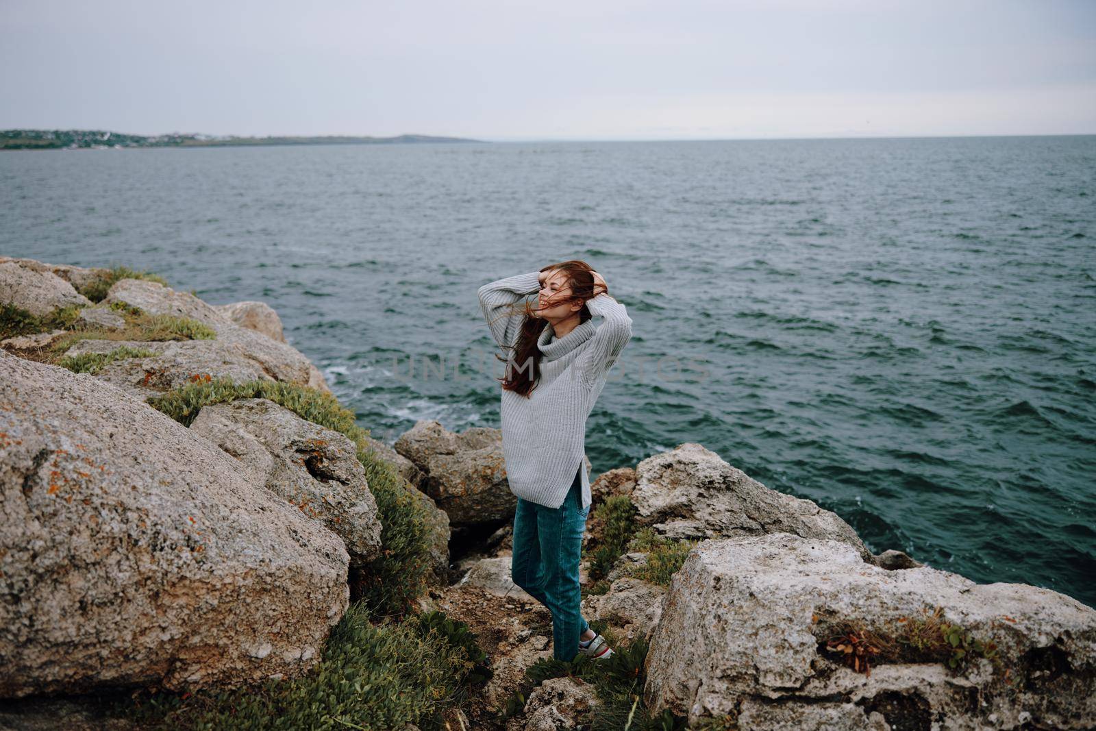 woman long hair nature rocks coast landscape female relaxing. High quality photo