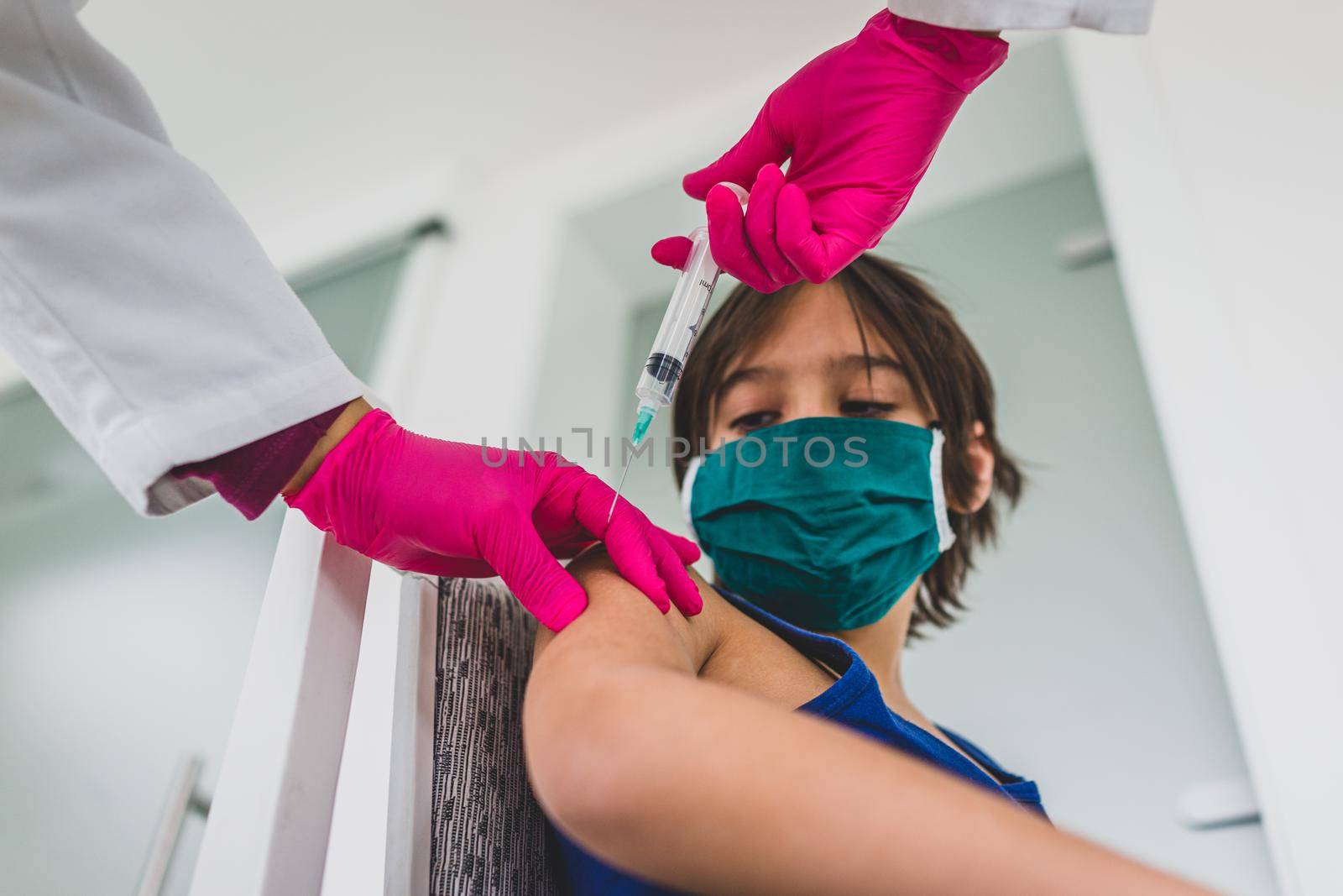 Little cute child with mask getting injection