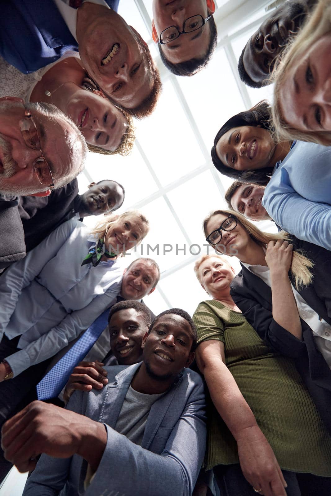 Large group of young and mature colleagues in formalwear standing in circle. Partnership concept