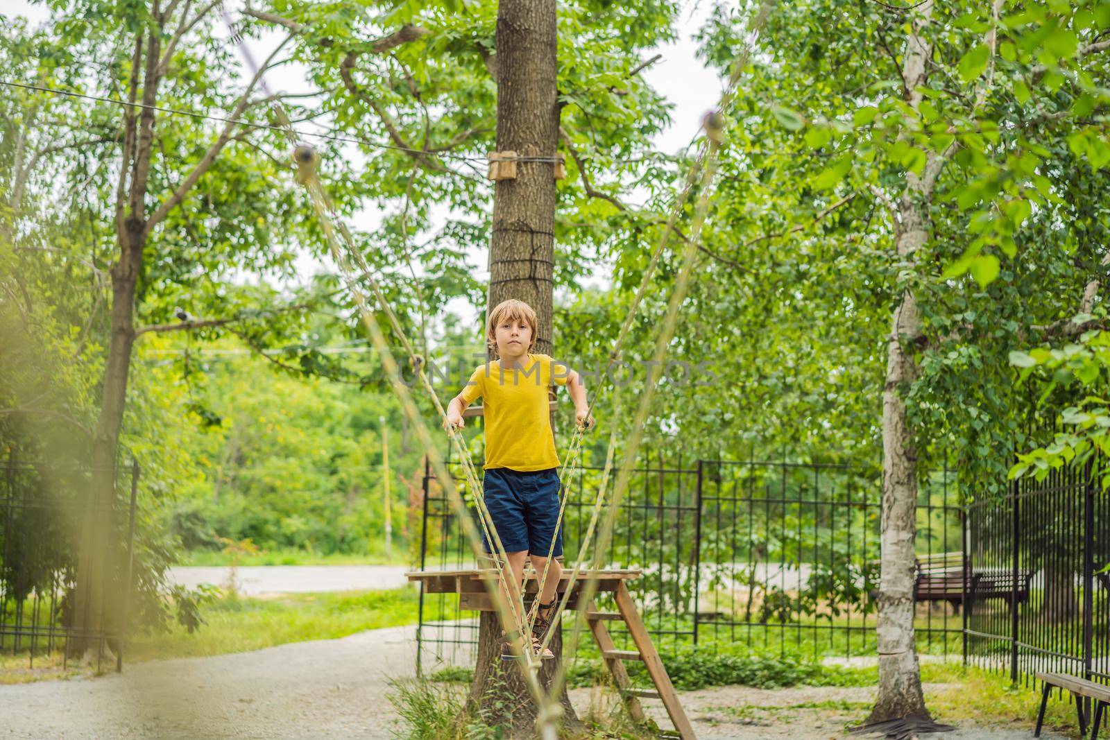 Little boy in a rope park. Active physical recreation of the child in the fresh air in the park. Training for children by galitskaya