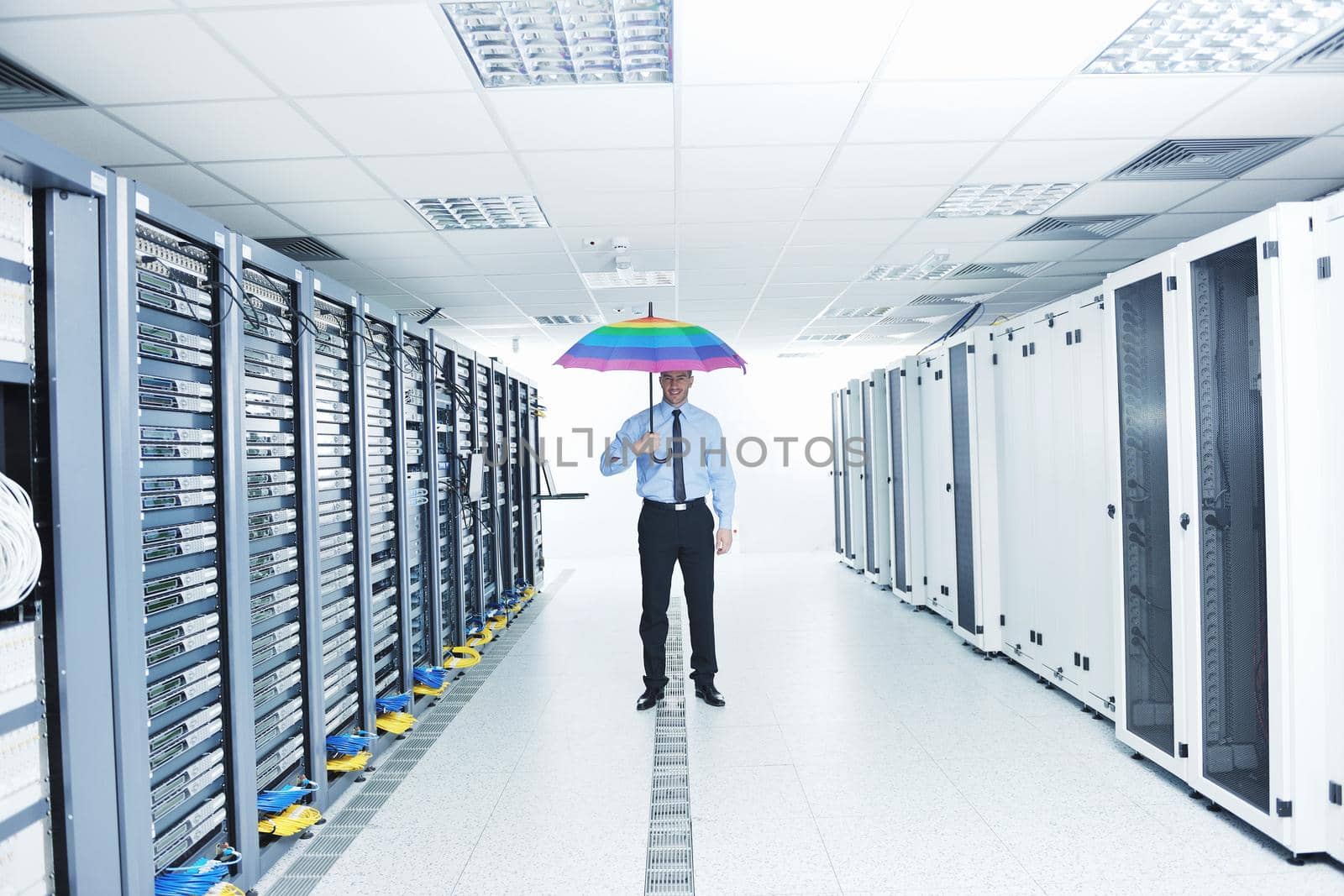 businessman hold umbrella in server room by dotshock