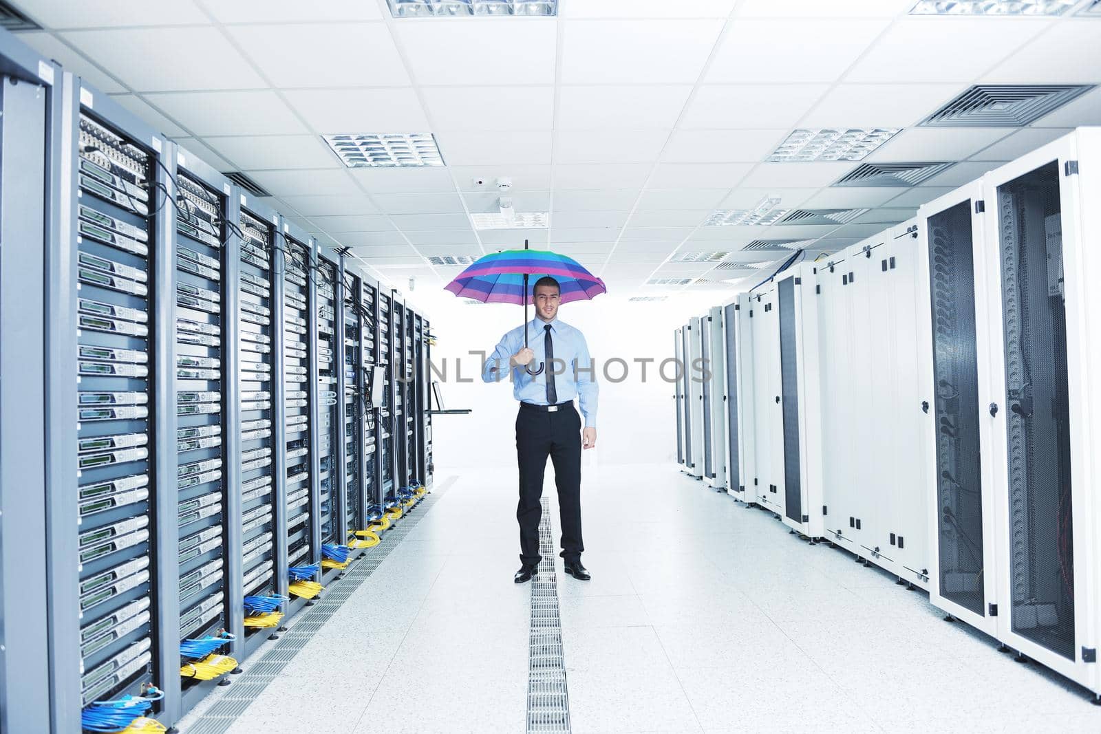 businessman hold umbrella in server room by dotshock