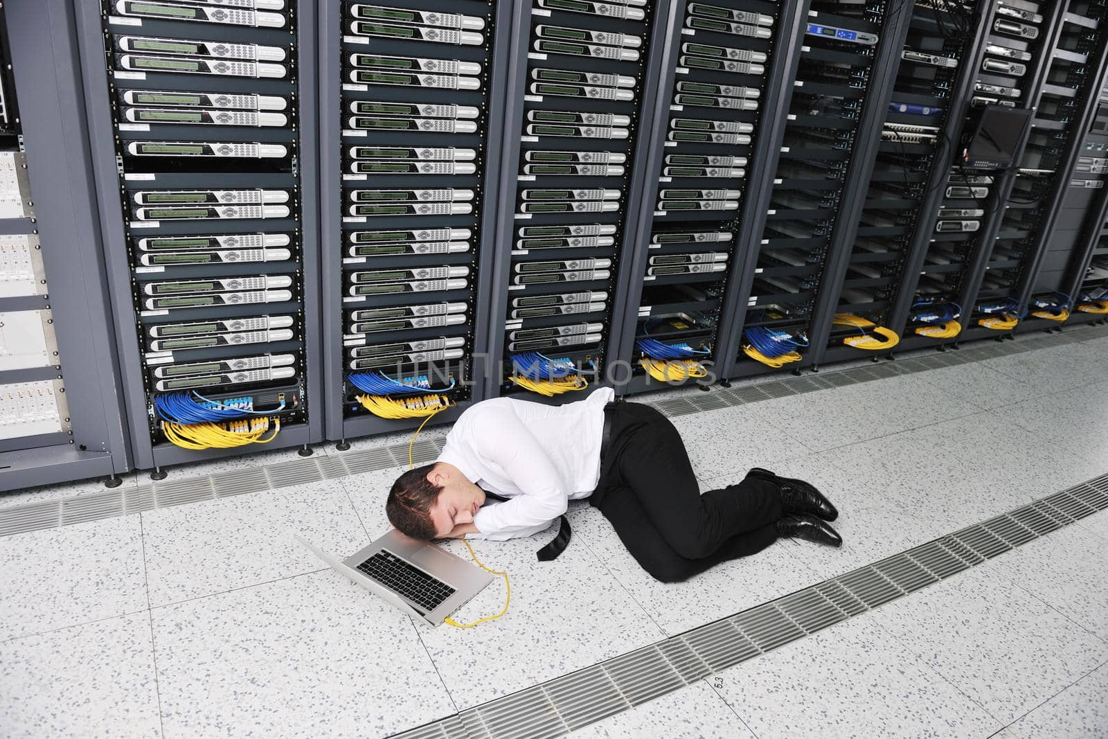 businessman with laptop in network server room by dotshock
