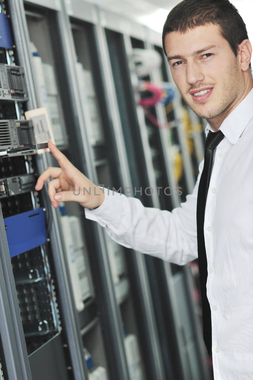 young engeneer in datacenter server room by dotshock