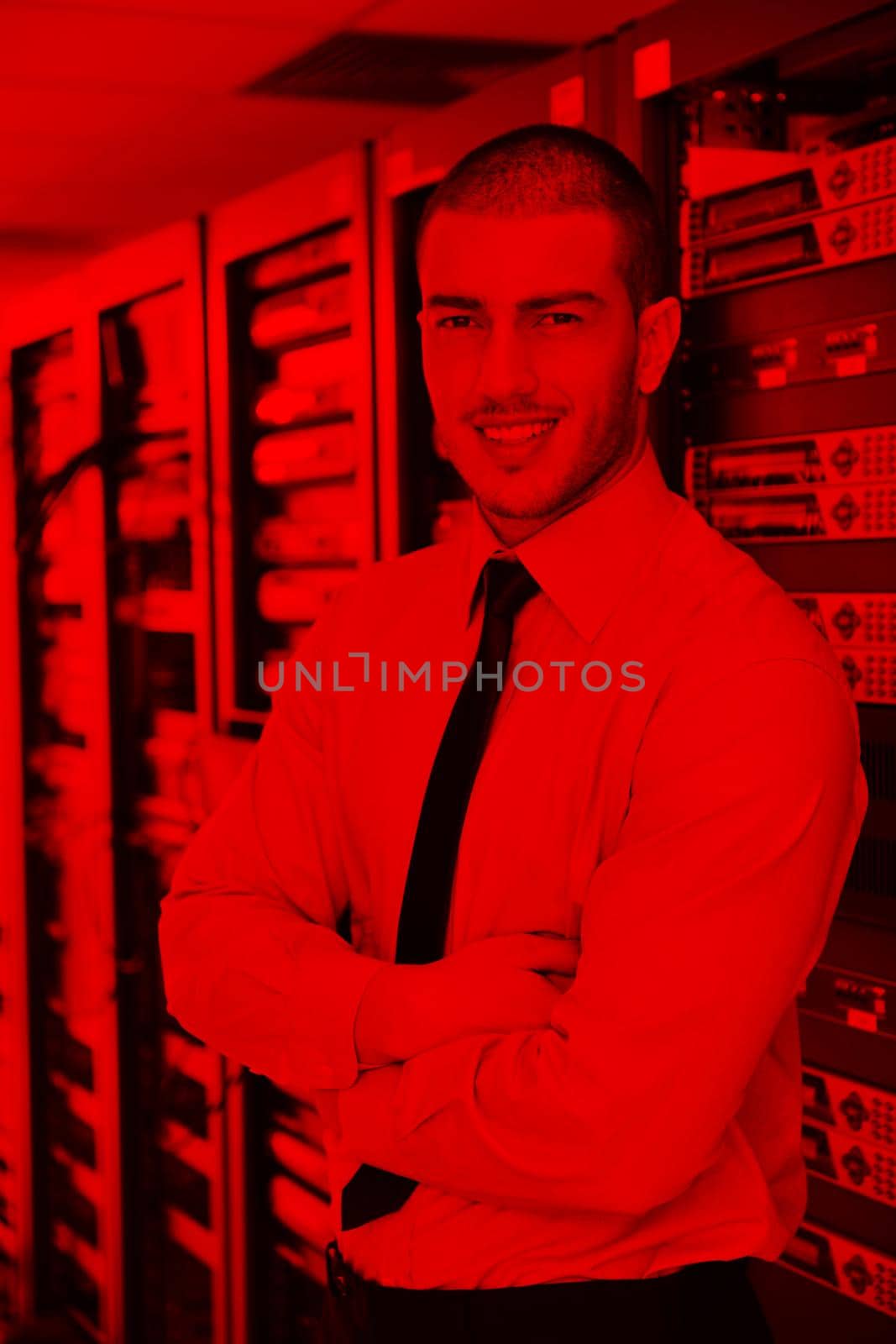 young it engineer in datacenter server room by dotshock