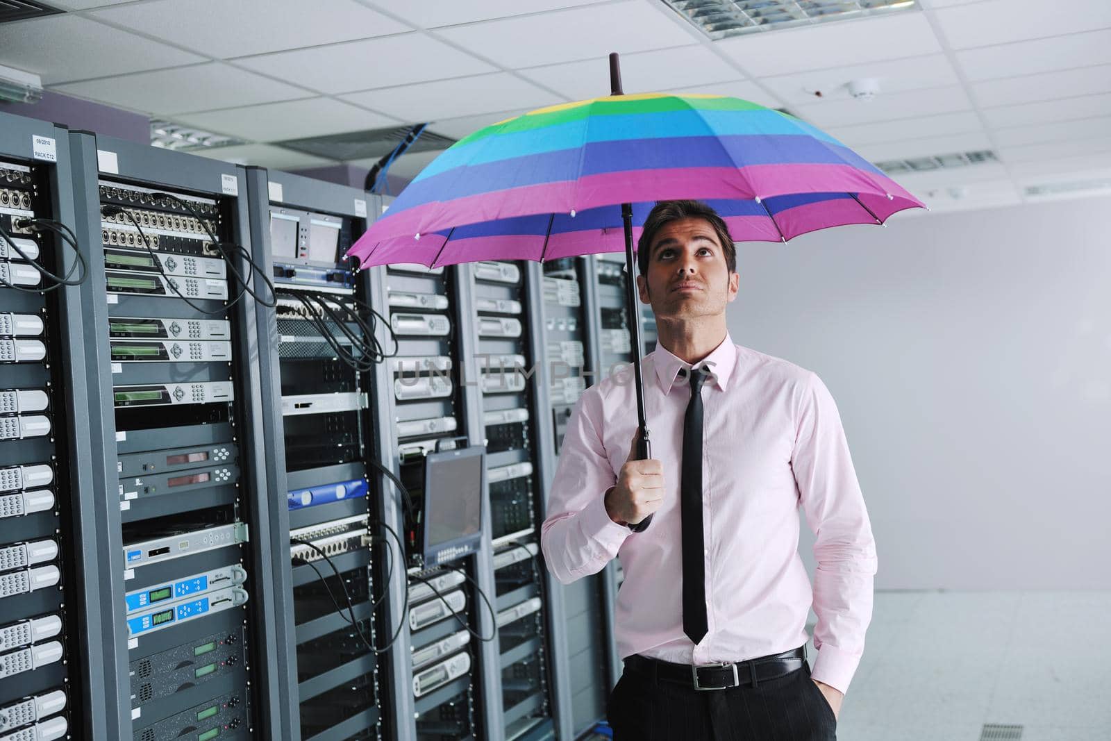 businessman hold umbrella in server room by dotshock