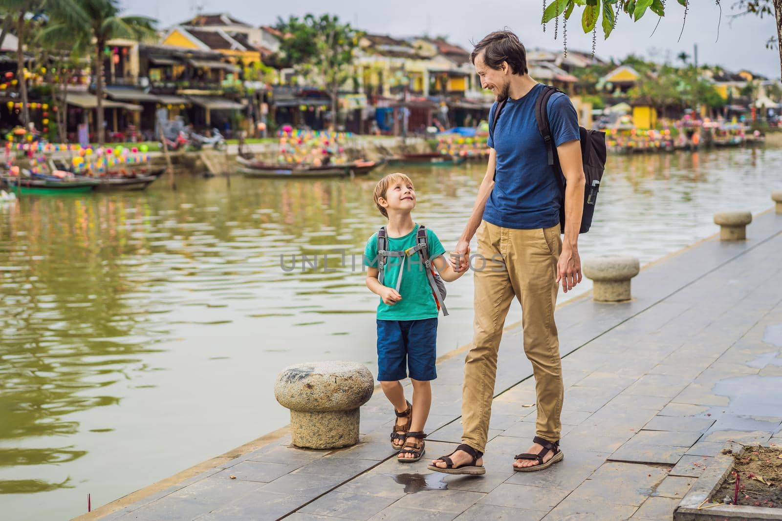 Dad and son travelers on background of Hoi An ancient town, Vietnam. Vietnam opens to tourists again after quarantine Coronovirus COVID 19.