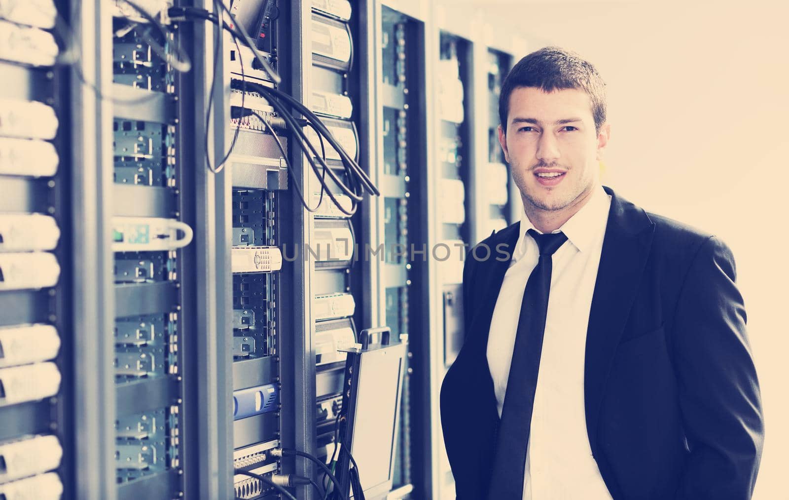 young it  engeneer business man with thin modern aluminium laptop in network server room