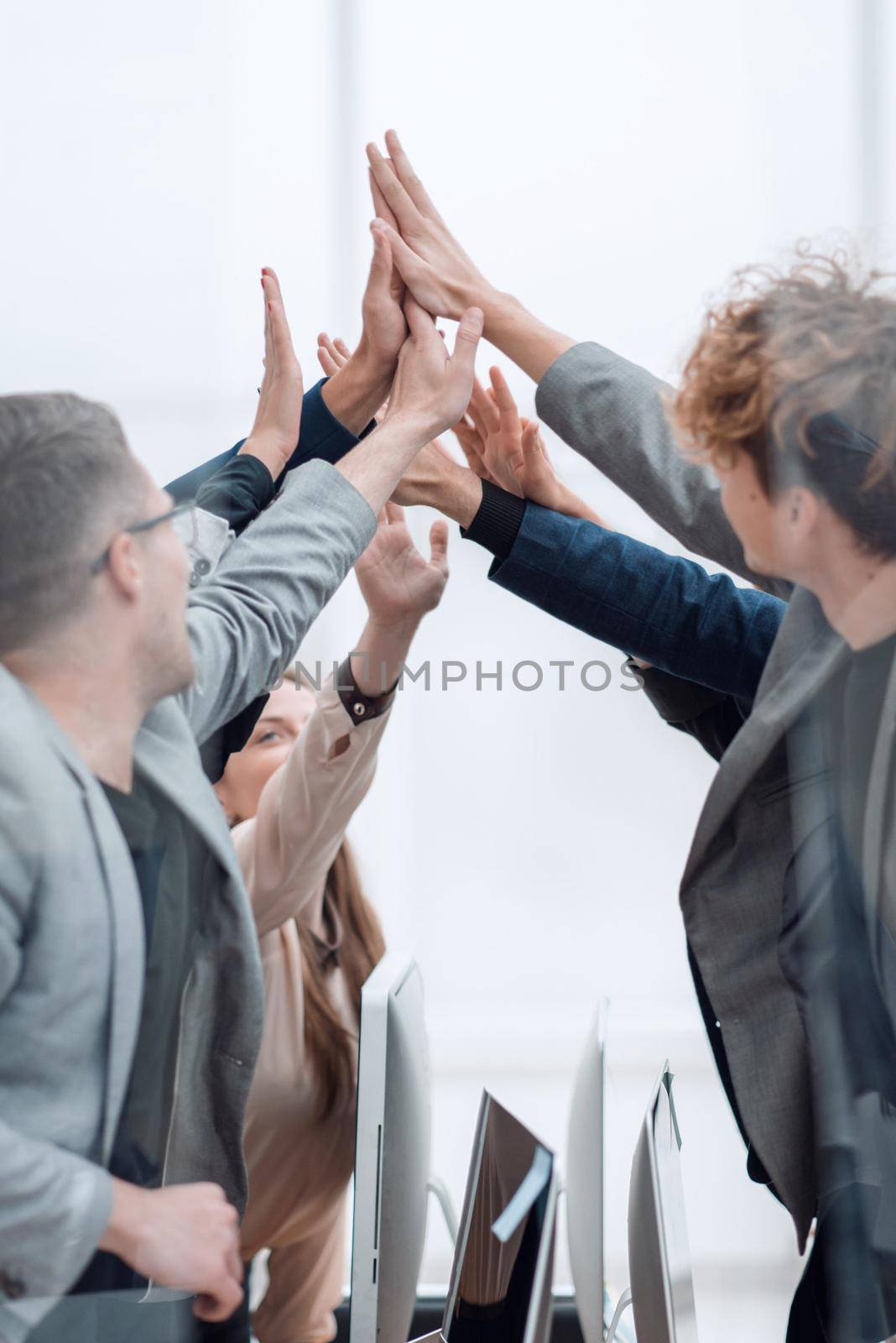 close up. a group of happy employees giving each other a high five.