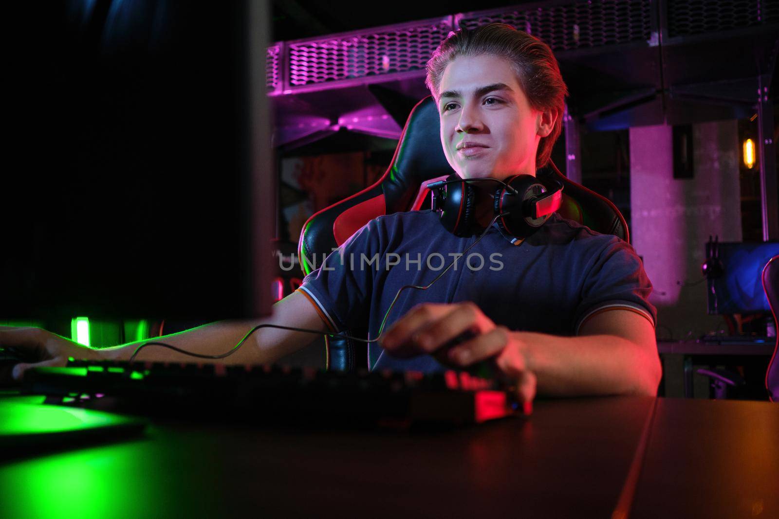 Professional photo of young male caucasian cyber sportsman in gaming club training for important match.