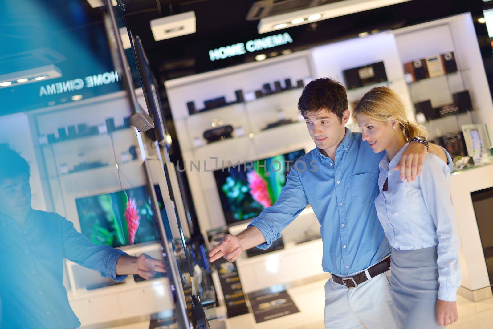 people in consumer electronics  retail store looking at latest laptop, television and photo camera to buy