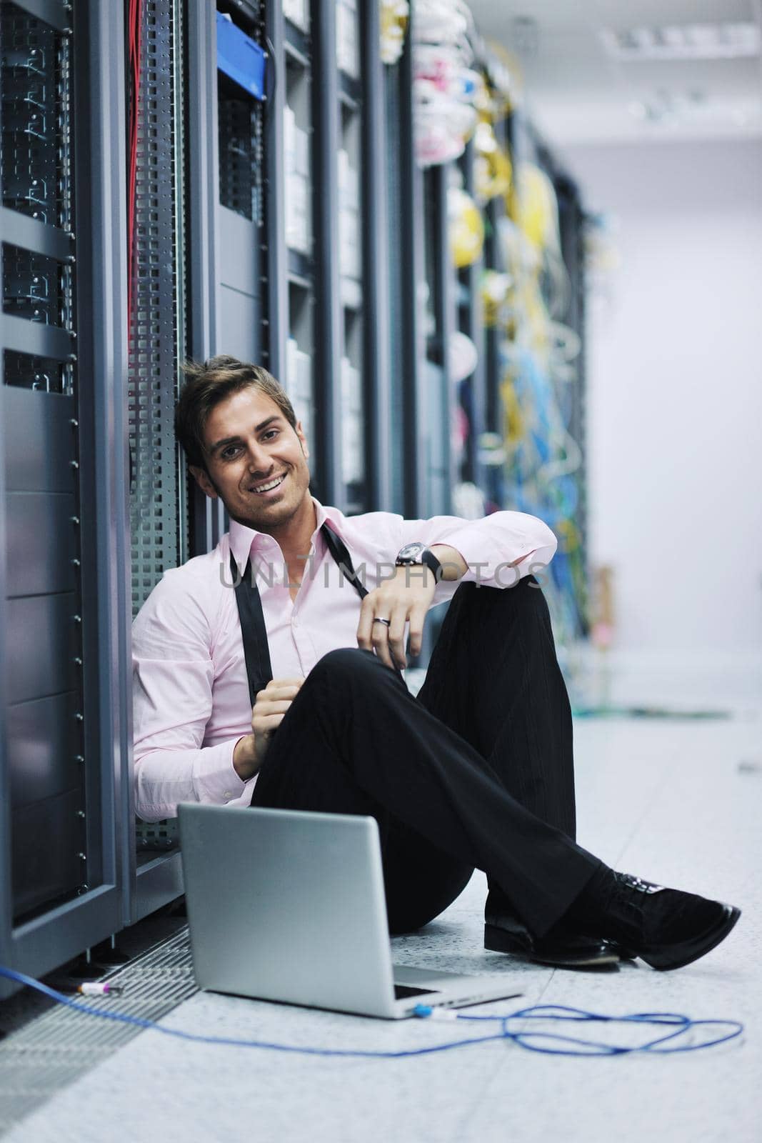 young engeneer business man with thin modern aluminium laptop in network server room