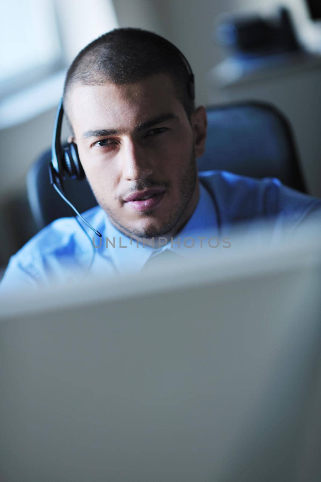 businessman with a headset portrait at bright call center helpdesk support office