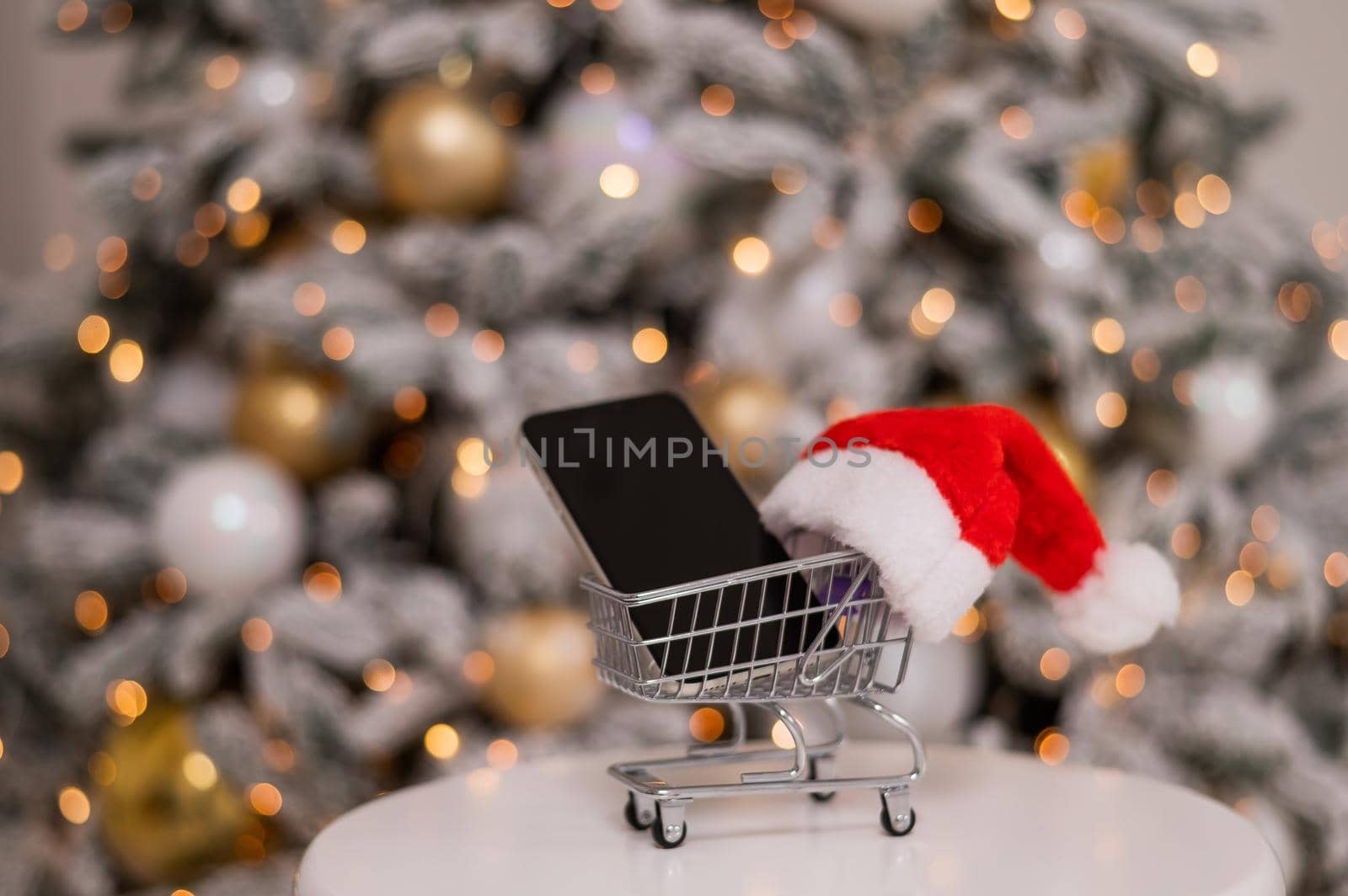 Smartphone with black screen in a shopping trolley. Online shopping for Christmas gifts